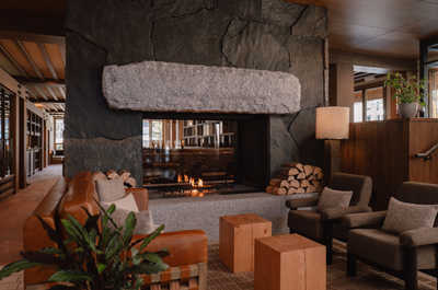 A cozy lounge space centered around a grand stone fireplace, exuding warmth and inviting relaxation after a long day of exploring.
