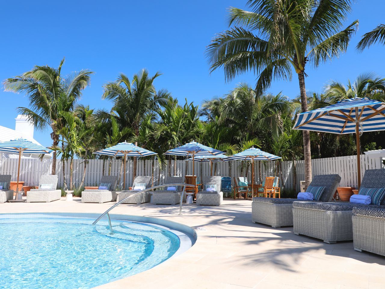 image Elegant poolside lounging shaded by swaying palms sets the stage for a relaxing day of indulgence.