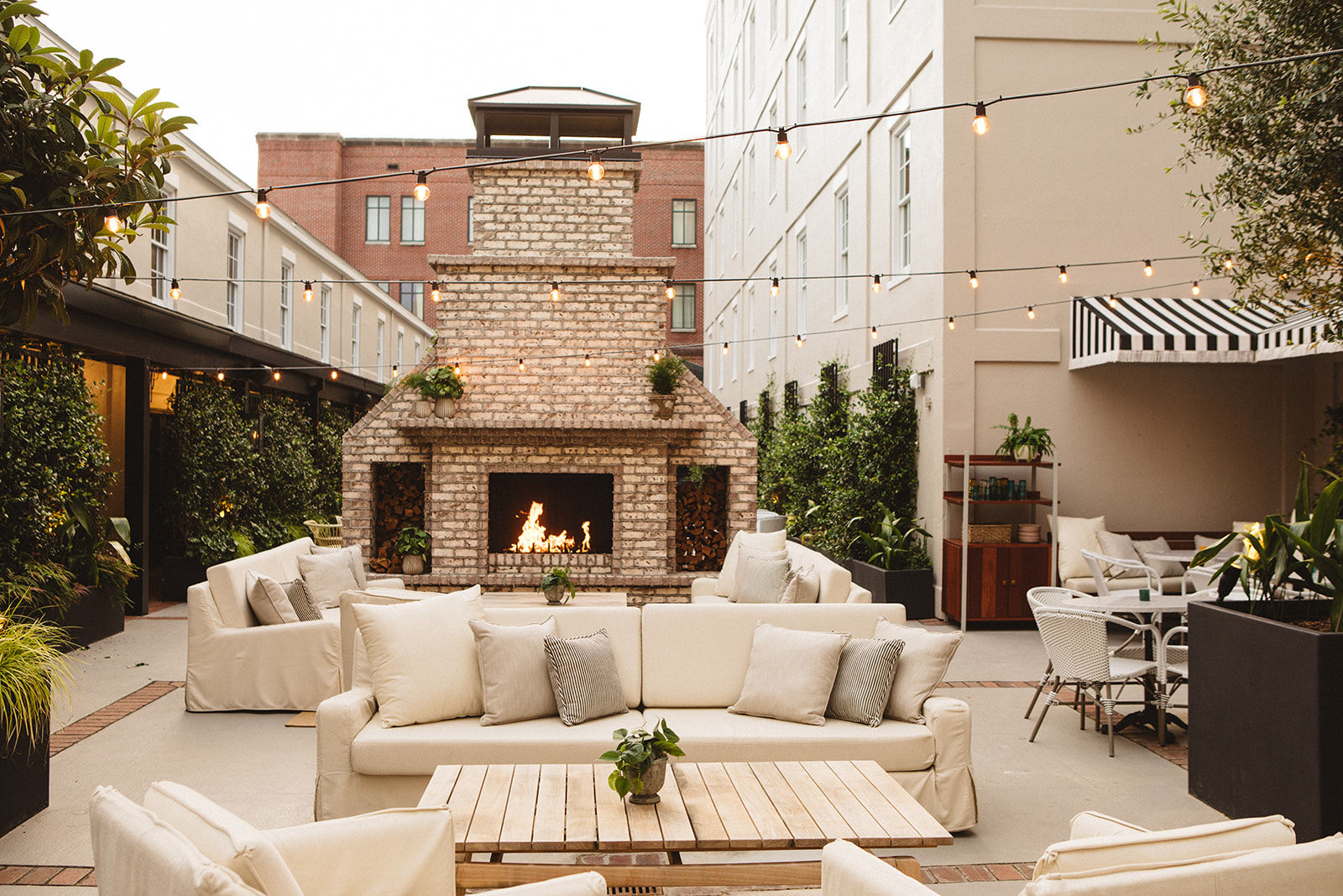 image Charming outdoor retreat, where plush seating and a grand brick fireplace create the perfect setting for relaxation and conversation.