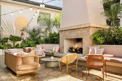 Bask in golden warmth beside the fire, where lush surroundings and soft seating invite you to linger.