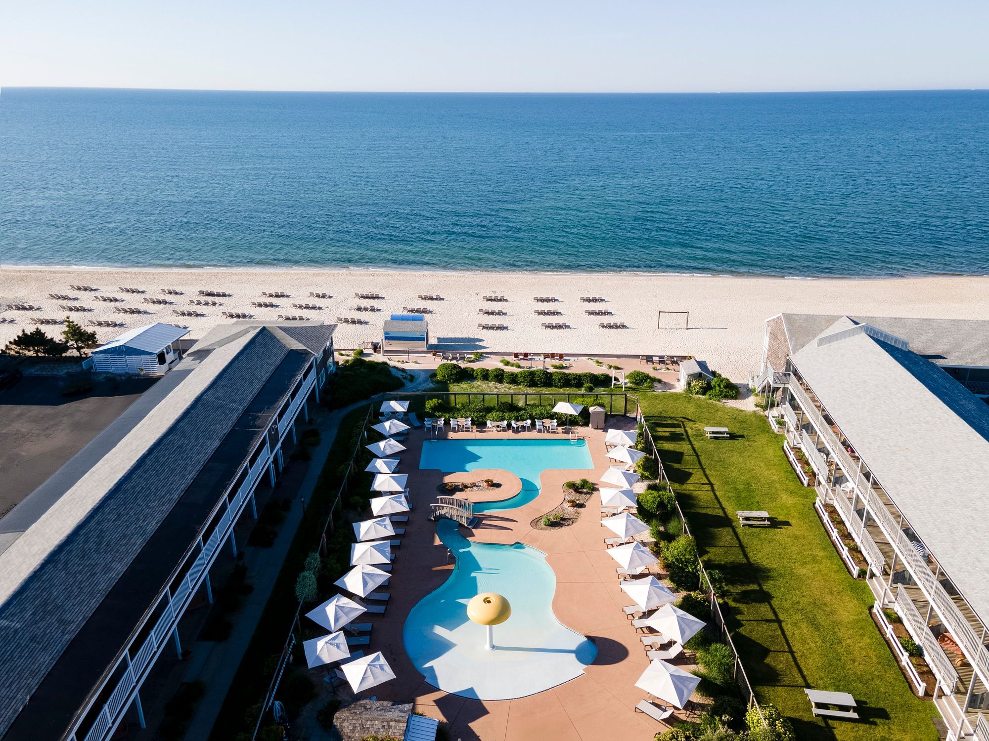 image Wake to seaside serenity where lush lawns, winding pools, and ocean breezes create the perfect escape.