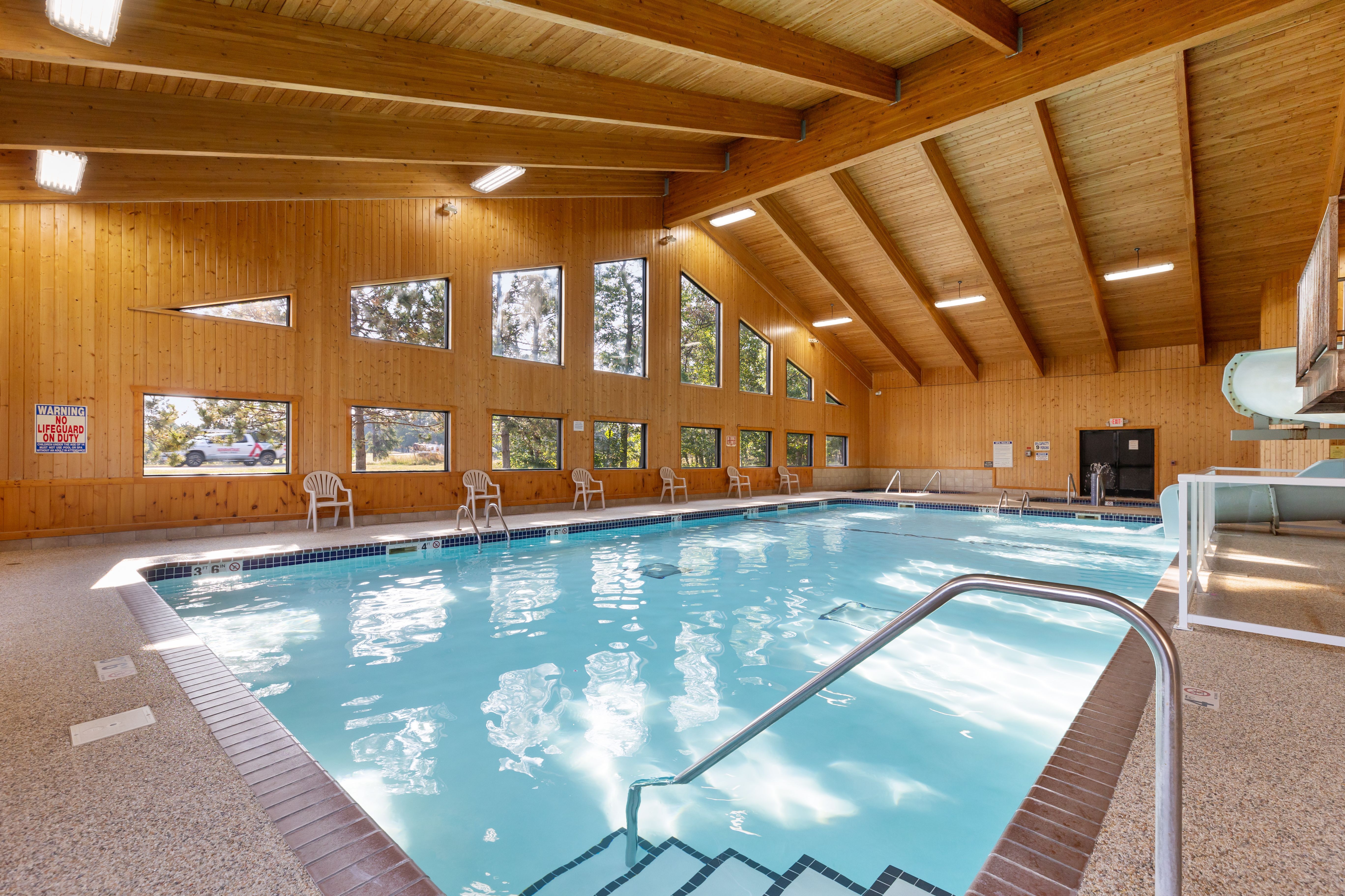 image Dive into relaxation at the indoor pool, featuring a thrilling waterslide amidst rustic wooden beams that evoke the charm of lakeside living.