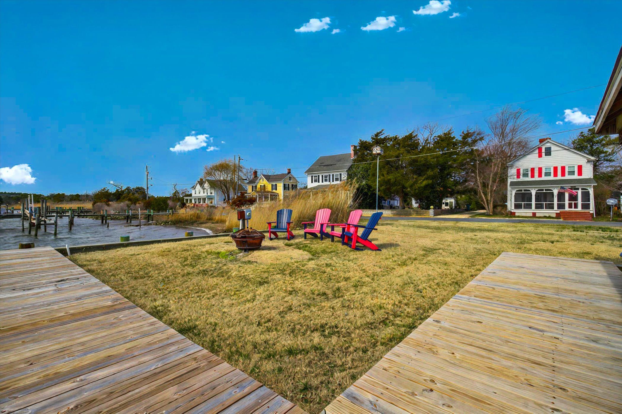 image Expansive riverside yard with direct access to the water and Adirondack seating.