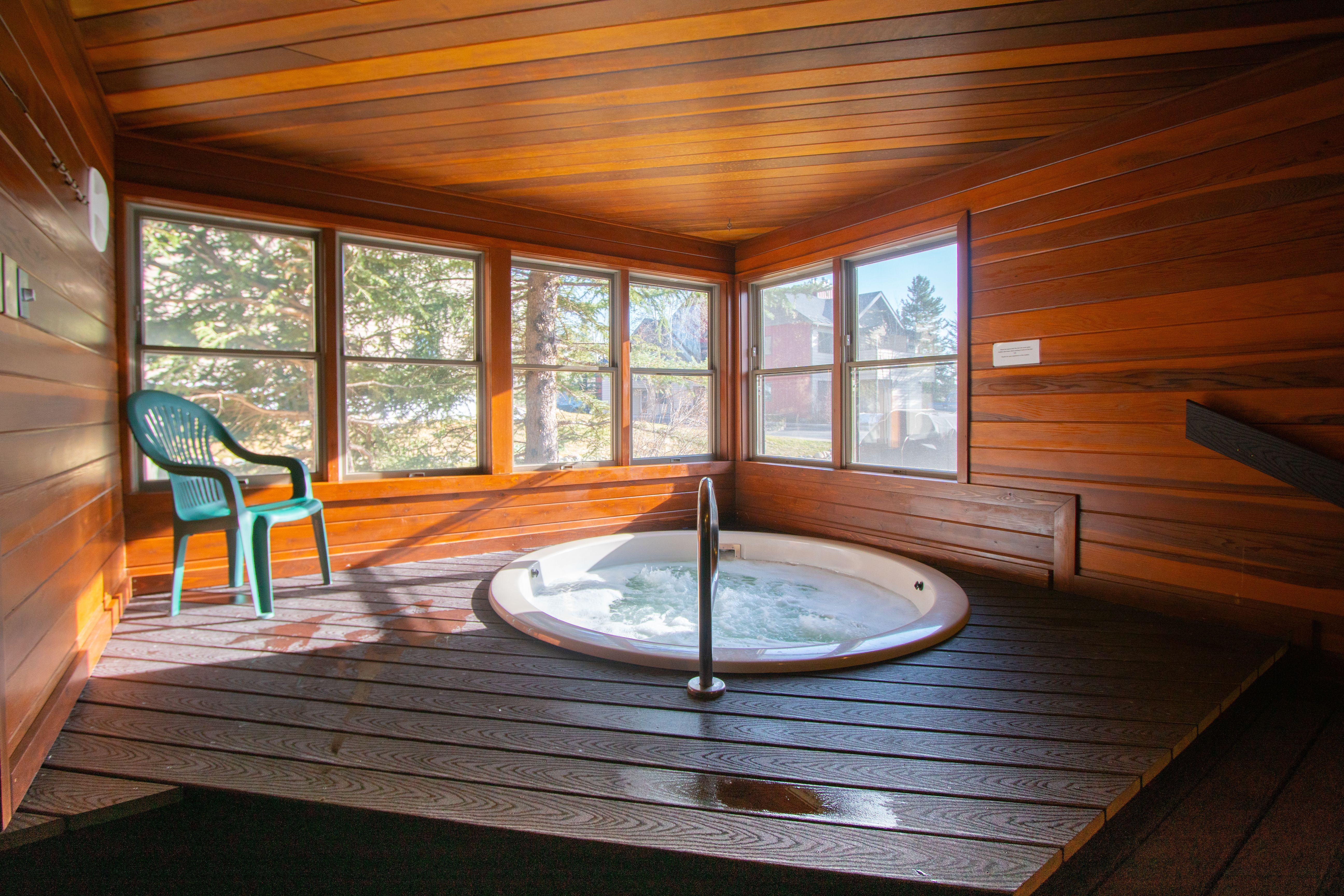 image A relaxing hot tub in a cozy wooden enclosure, offering a perfect spot to unwind while enjoying idyllic views of the surrounding landscape.