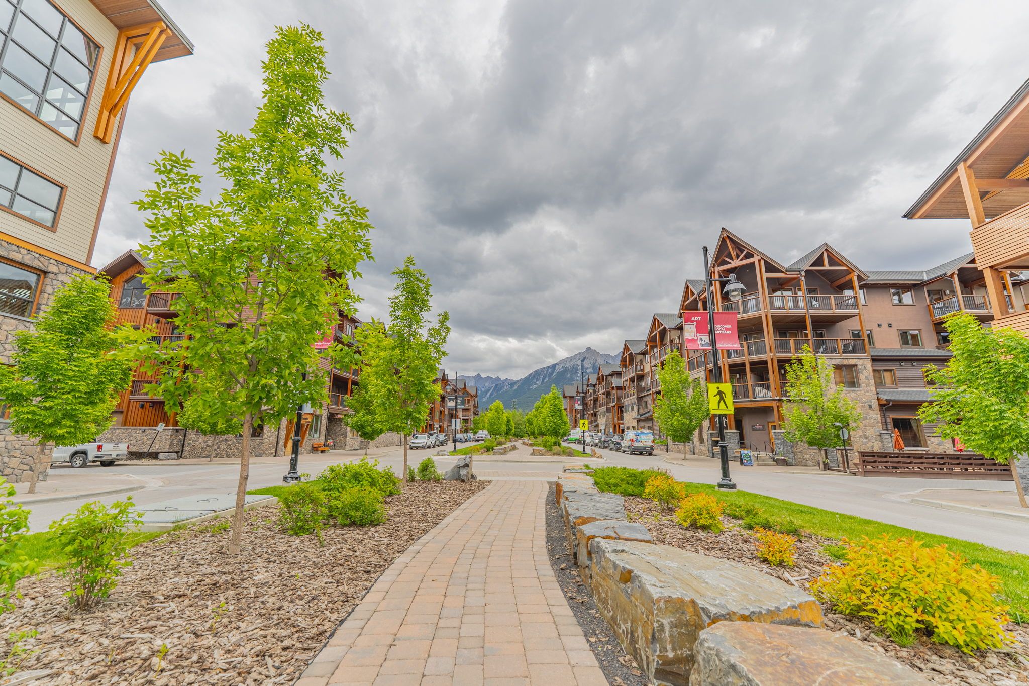 image A charming walkway guides you through vibrant greenery and modern buildings, inviting exploration.