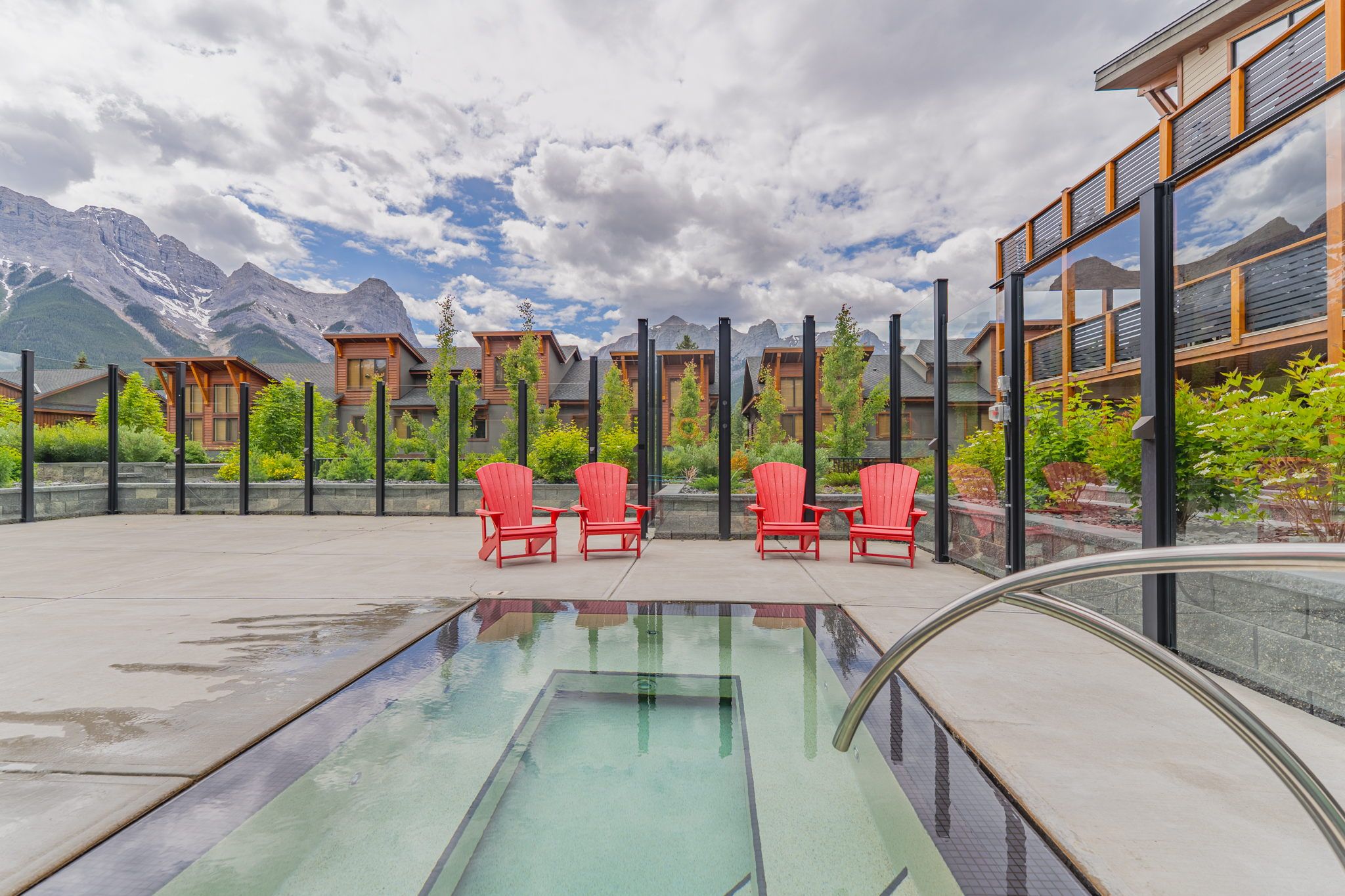 image Relax in stylish red chairs, perfectly positioned near a tranquil hot tub.