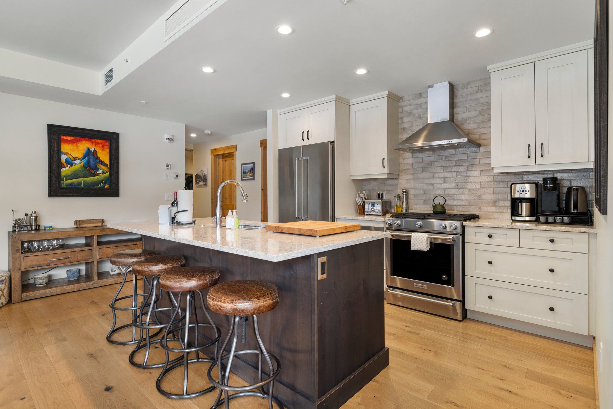 image Fully equipped kitchen with stainless steel appliances and a central island for casual dining or meal prep.