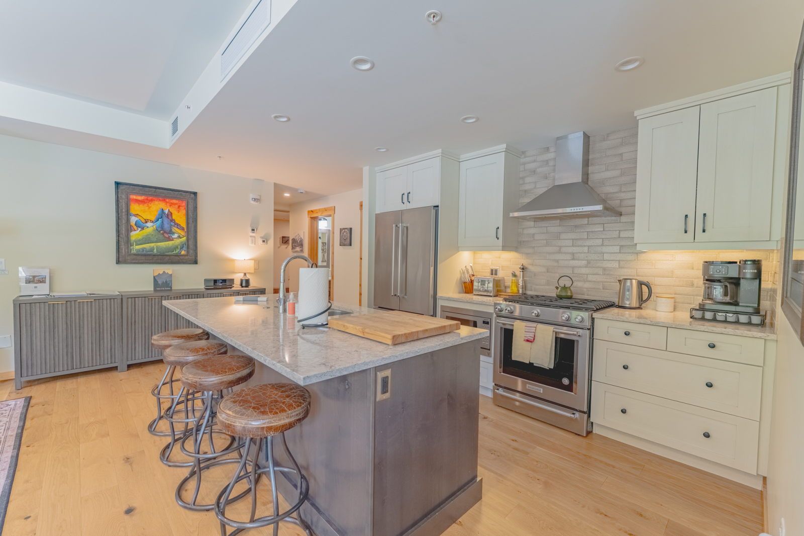 image Kitchen with granite countertops, stainless steel appliances, and bar stools