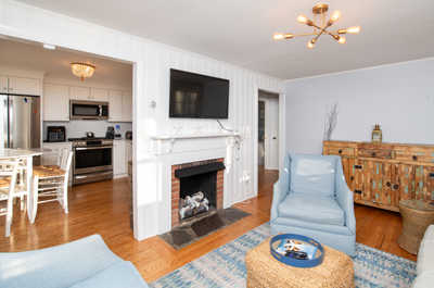 Open-concept living and dining area with fireplace and bar seating, designed for cozy nights and easy entertaining.