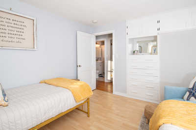 Cozy twin bedroom with cheerful decor and easy access to the rest of the home — great for family stays.  Photo 18: