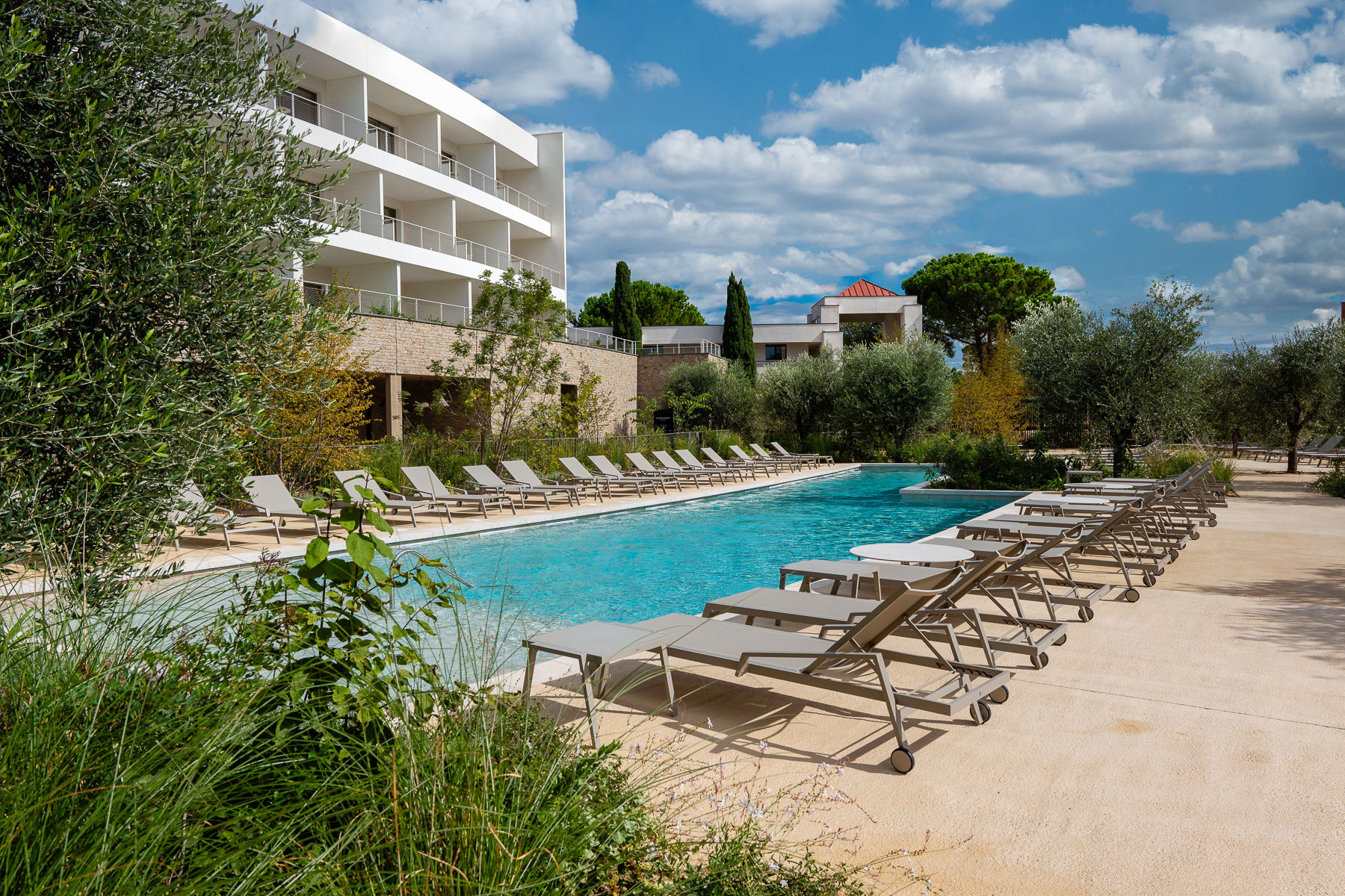 image Spacious outdoor pool surrounded by lush Mediterranean greenery—perfect for a refreshing dip under the sun.