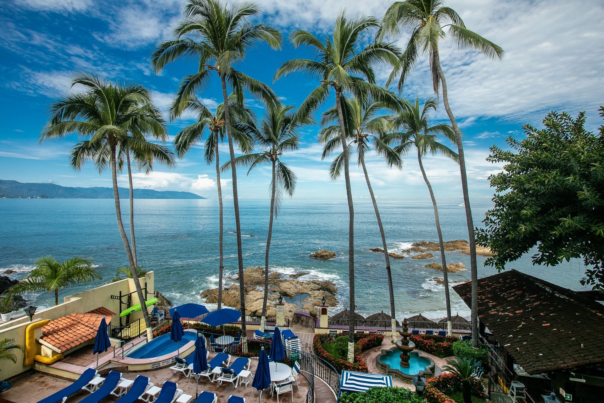 image Experience stunning oceanfront views framed by lush palm trees, inviting you to relax and enjoy the beauty of Puerto Vallarta.