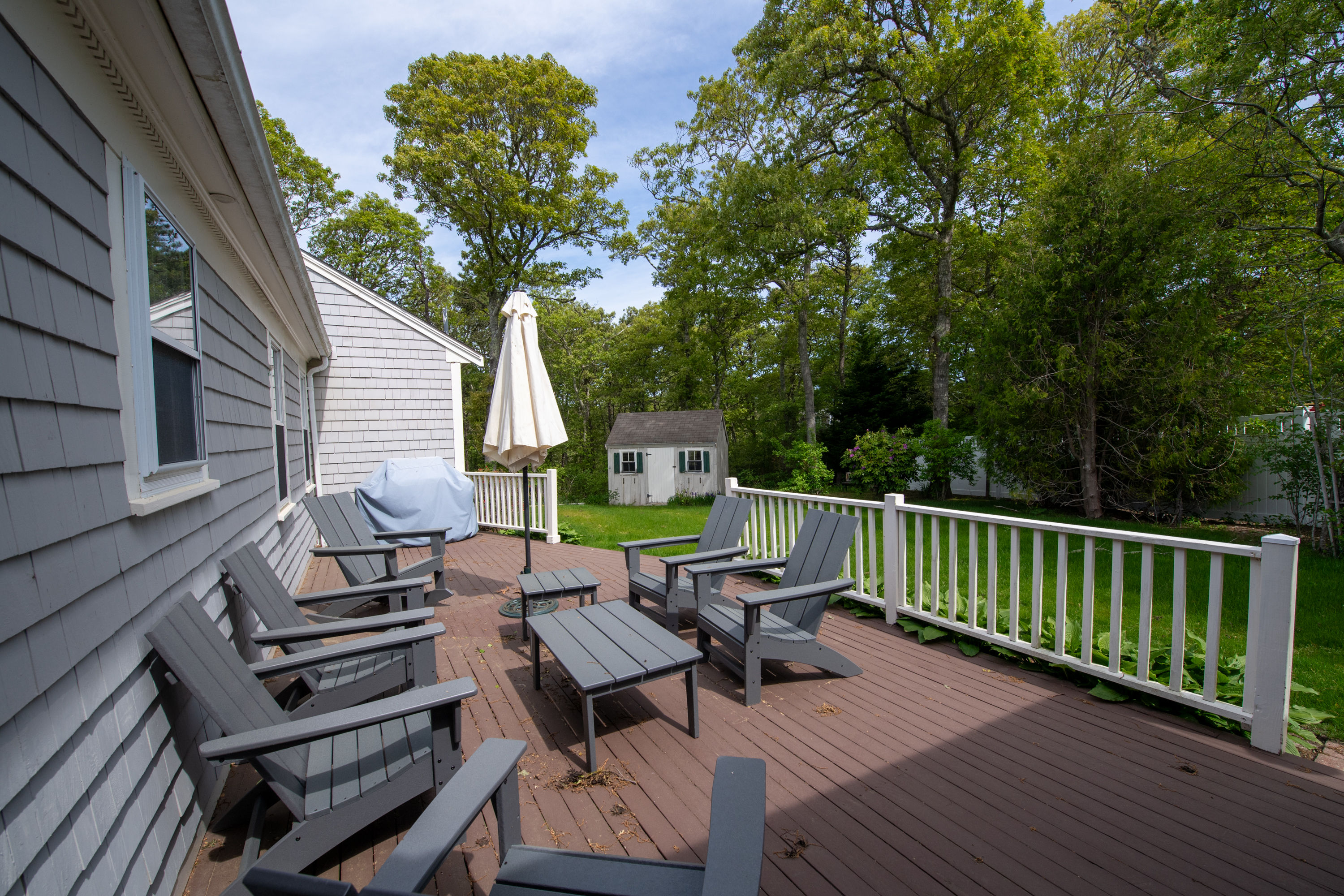 image Furnished back deck with umbrella-shaded seating—perfect for outdoor meals and relaxing in the Cape breeze.
