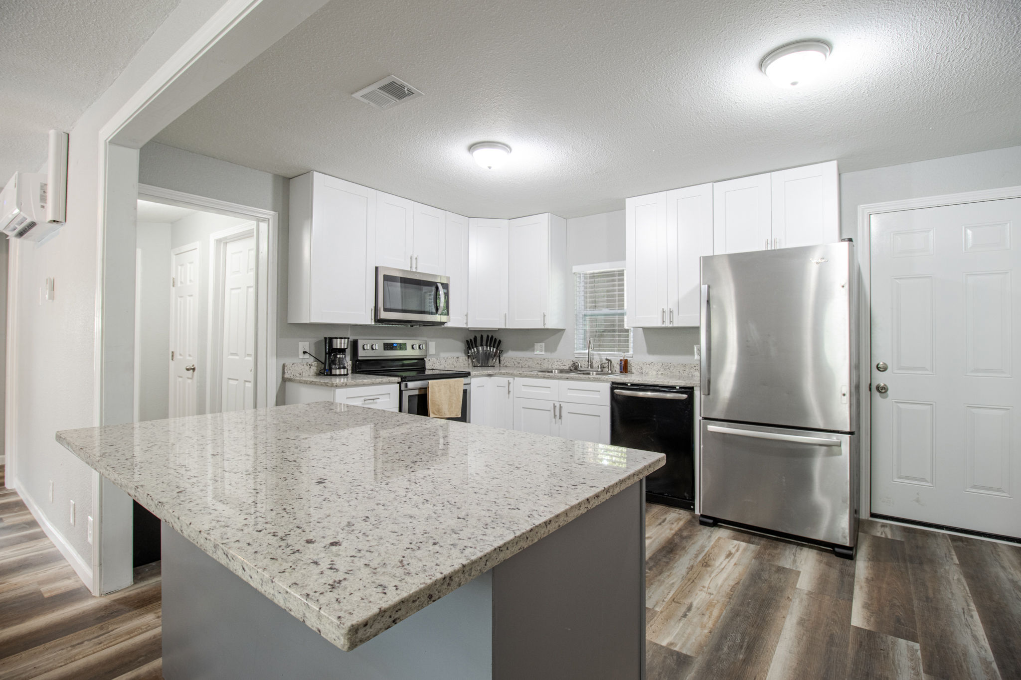 image Experience modern coastal living in this bright kitchen, featuring stainless steel appliances and ample counter space for culinary creations.