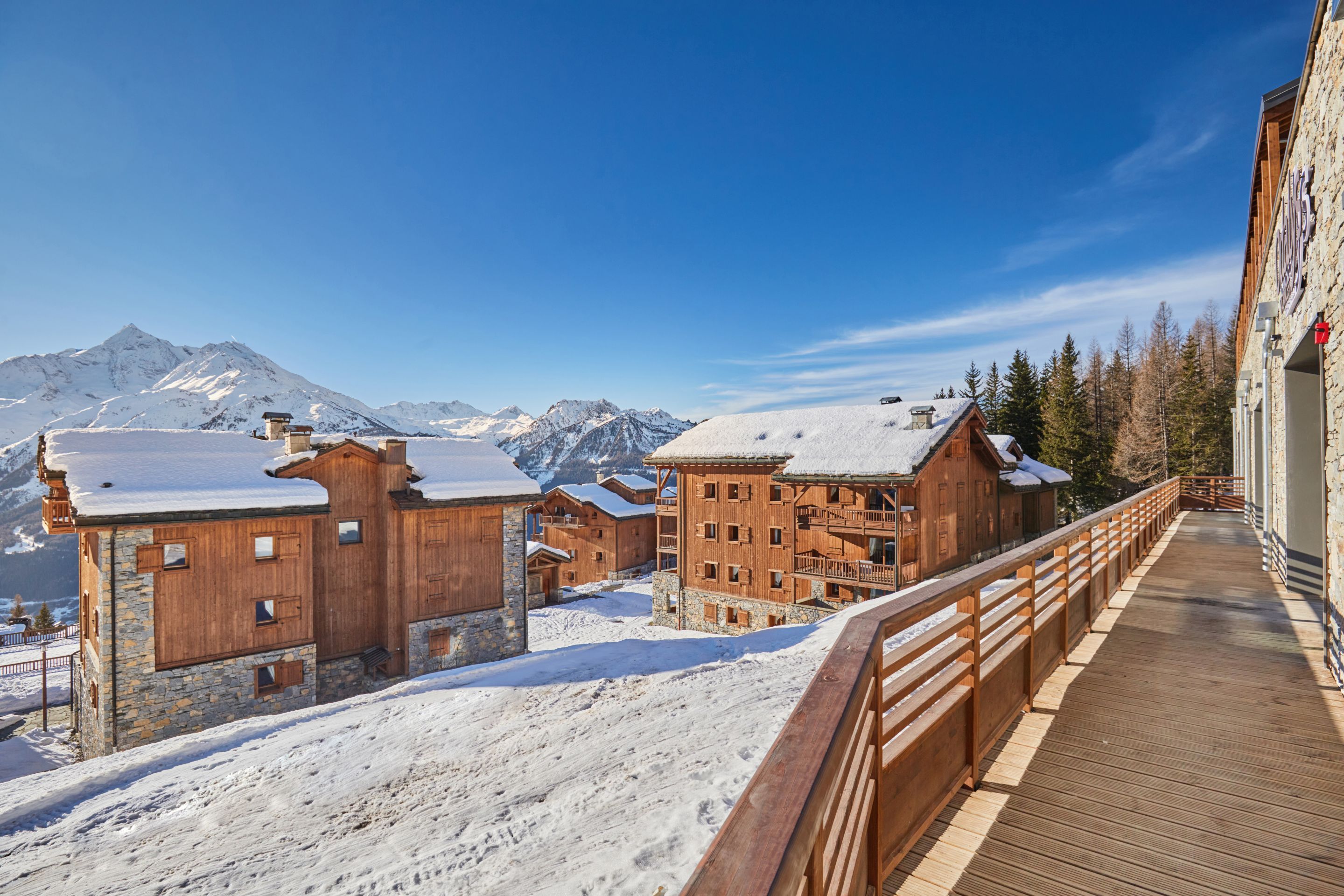 image Snow-covered chalets line the walkway outside, with the ski runs of La Rosière rising in the background.