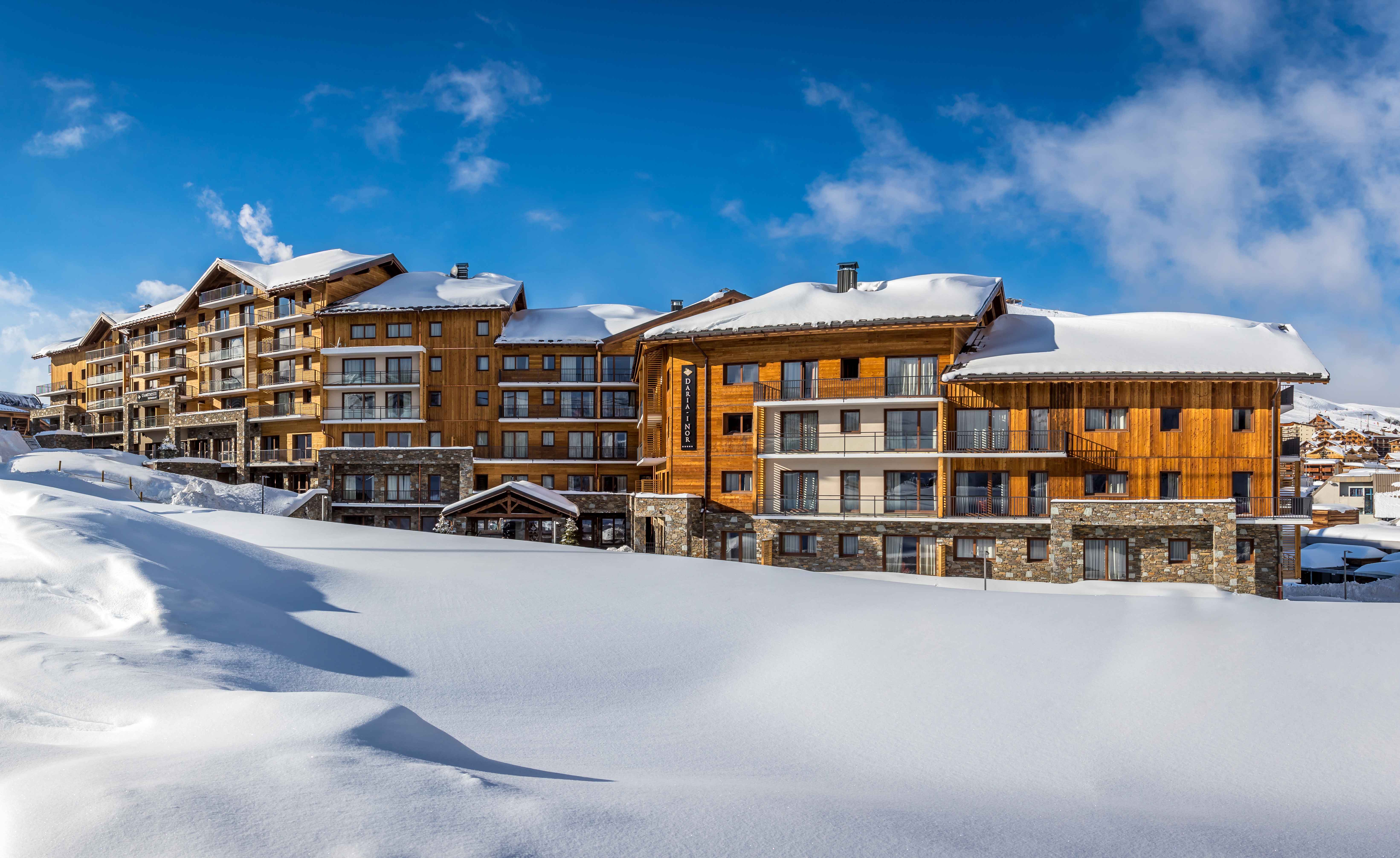 image Golden wood tones glow against a snowy backdrop—Daria-I Nor invites you into the warmth of luxury living.