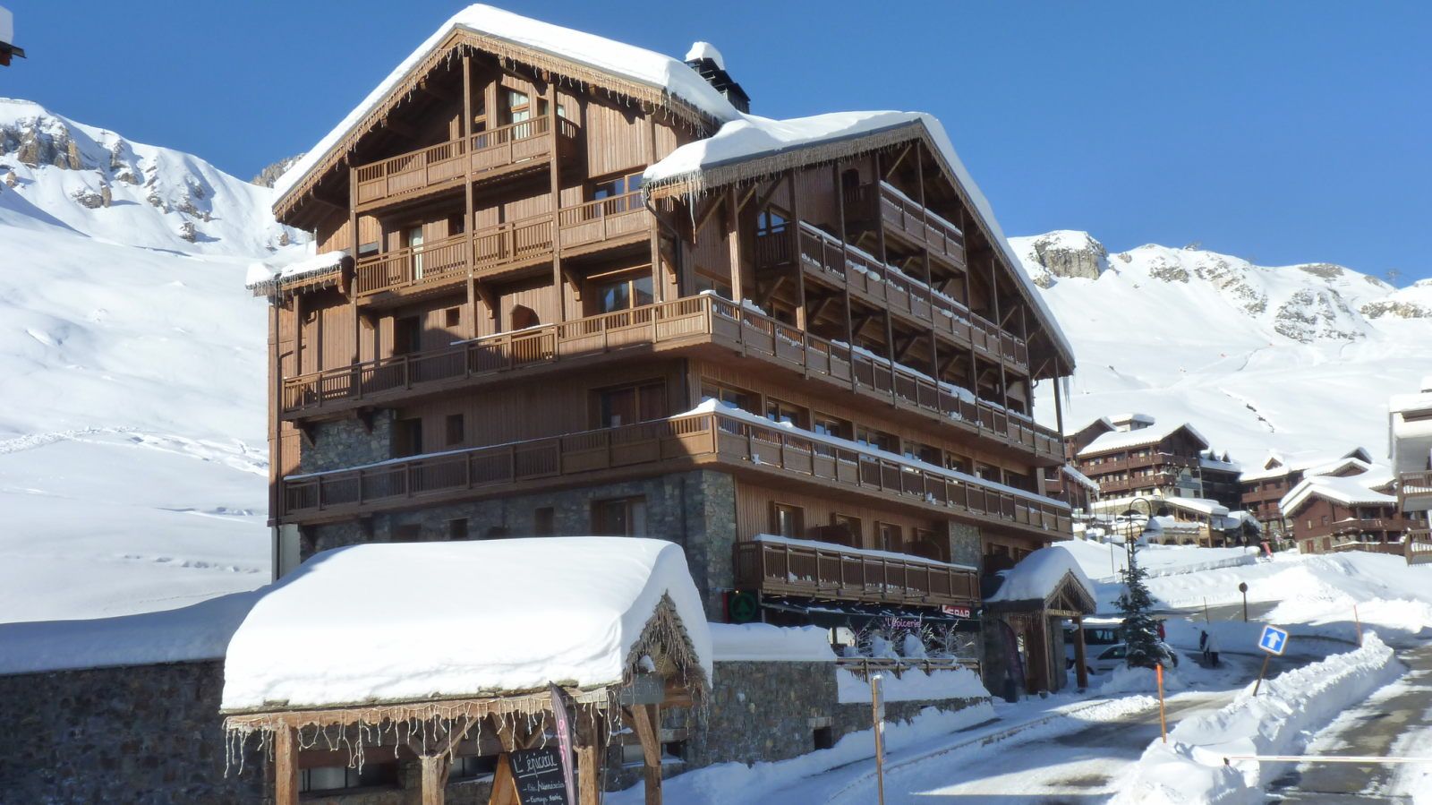 image Snow-draped lodge nestled beneath clear blue skies and dramatic mountain peaks