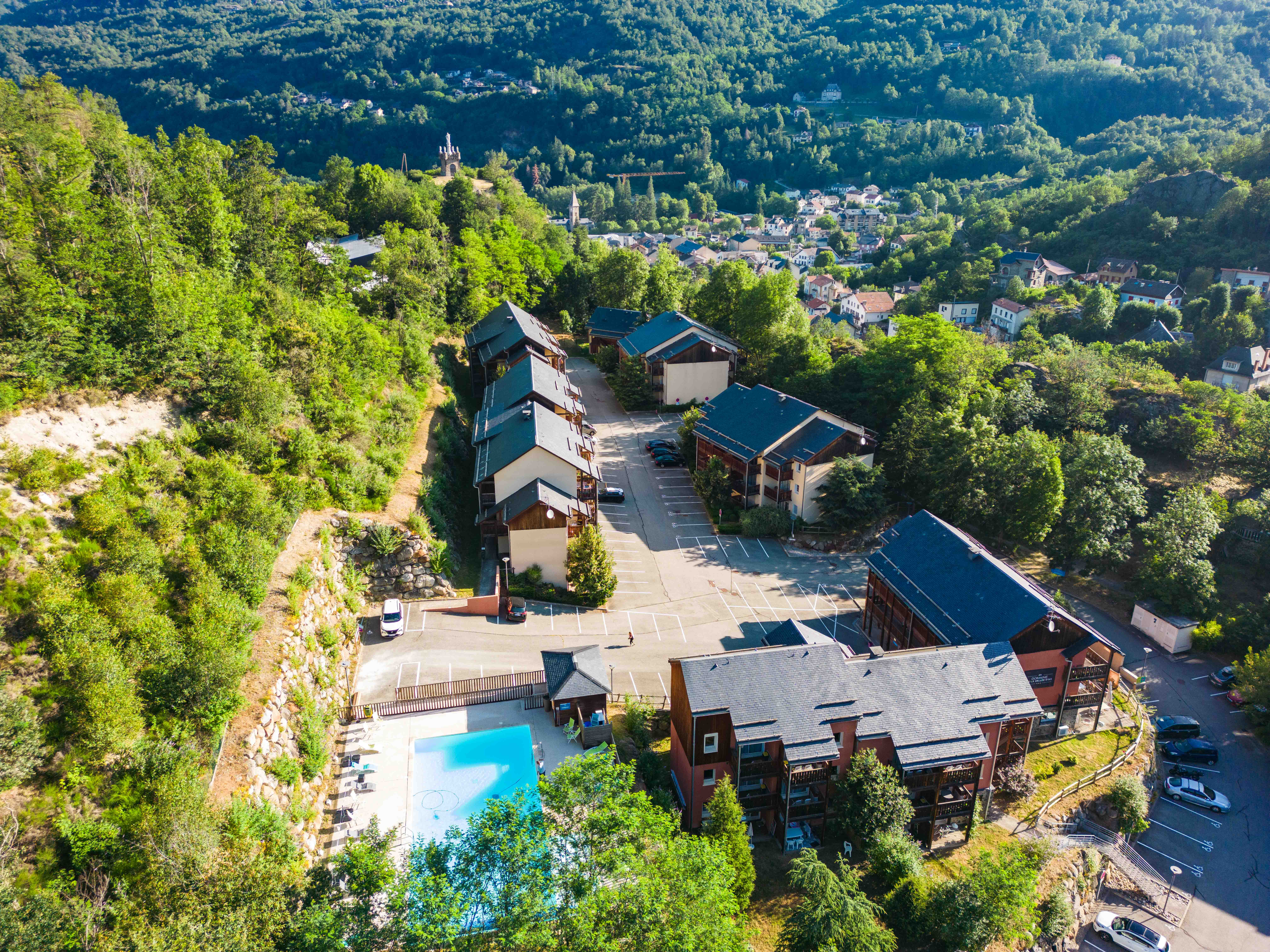 image Aerial view of the residence nestled among forested hills, highlighting the serene mountain surroundings.
