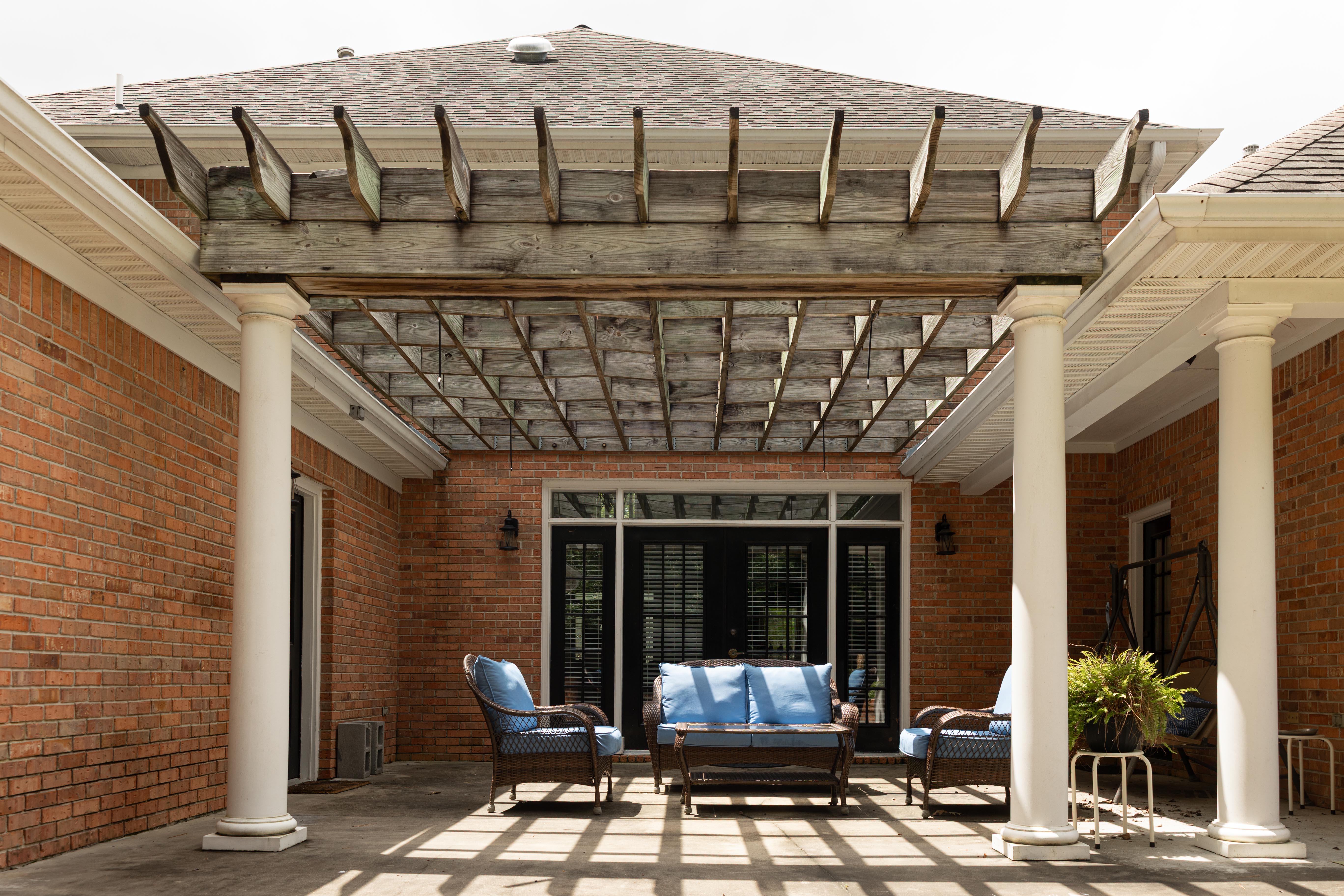 image Enjoy outdoor relaxation in the charming patio area, complete with comfortable seating and a lovely overhead trellis.