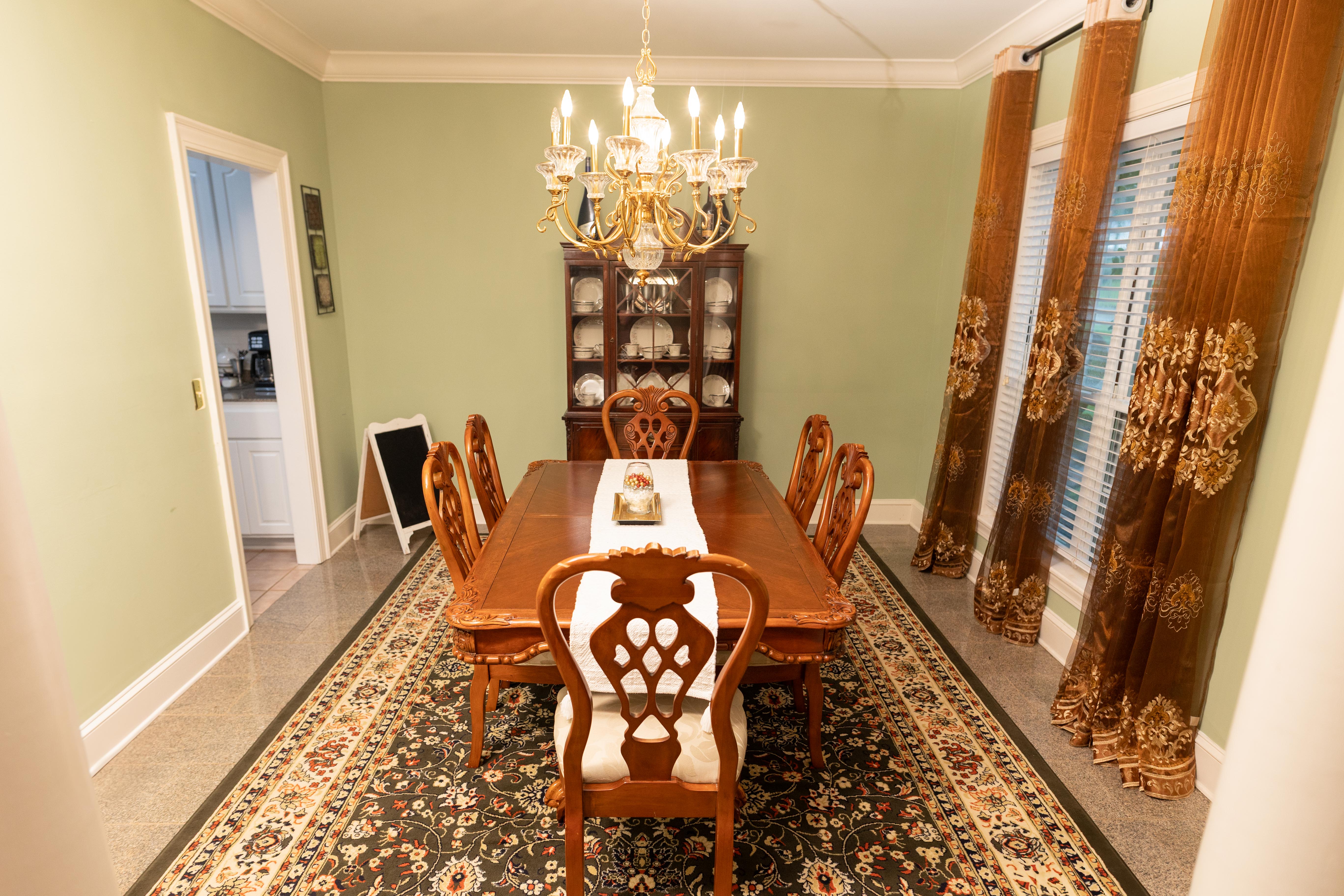 image The elegant dining room is perfect for gatherings, showcasing a classic chandelier and refined wooden table.