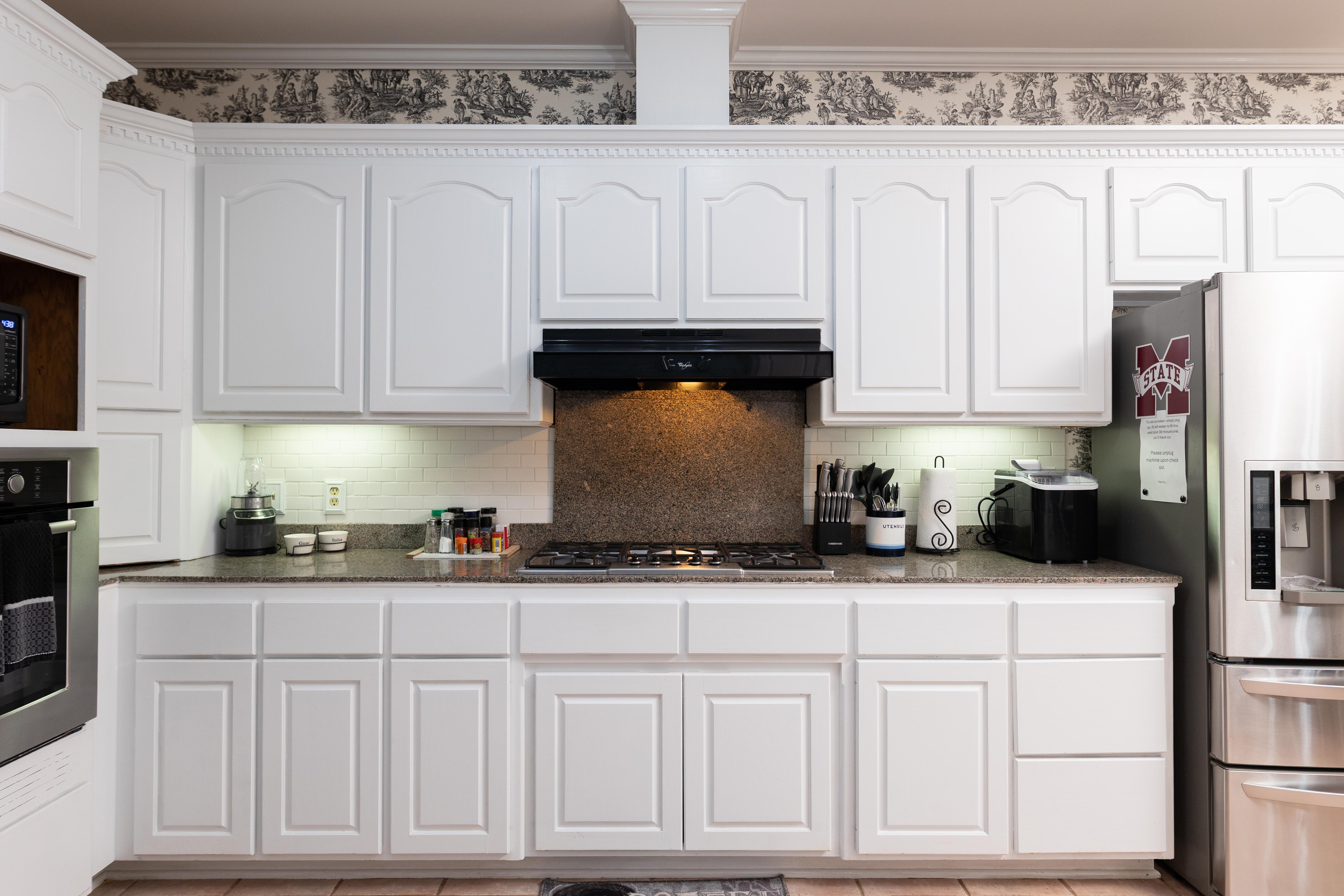 image Cook in style in the fully equipped kitchen, featuring modern appliances and ample white cabinetry for all your culinary needs.