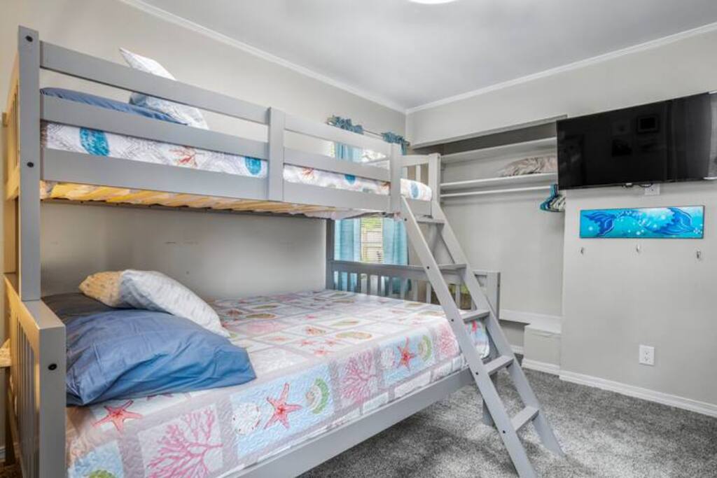 image The cheerful bunk room is perfect for kids or friends, featuring cozy bedding, playful decor, and a wall-mounted TV for entertainment.