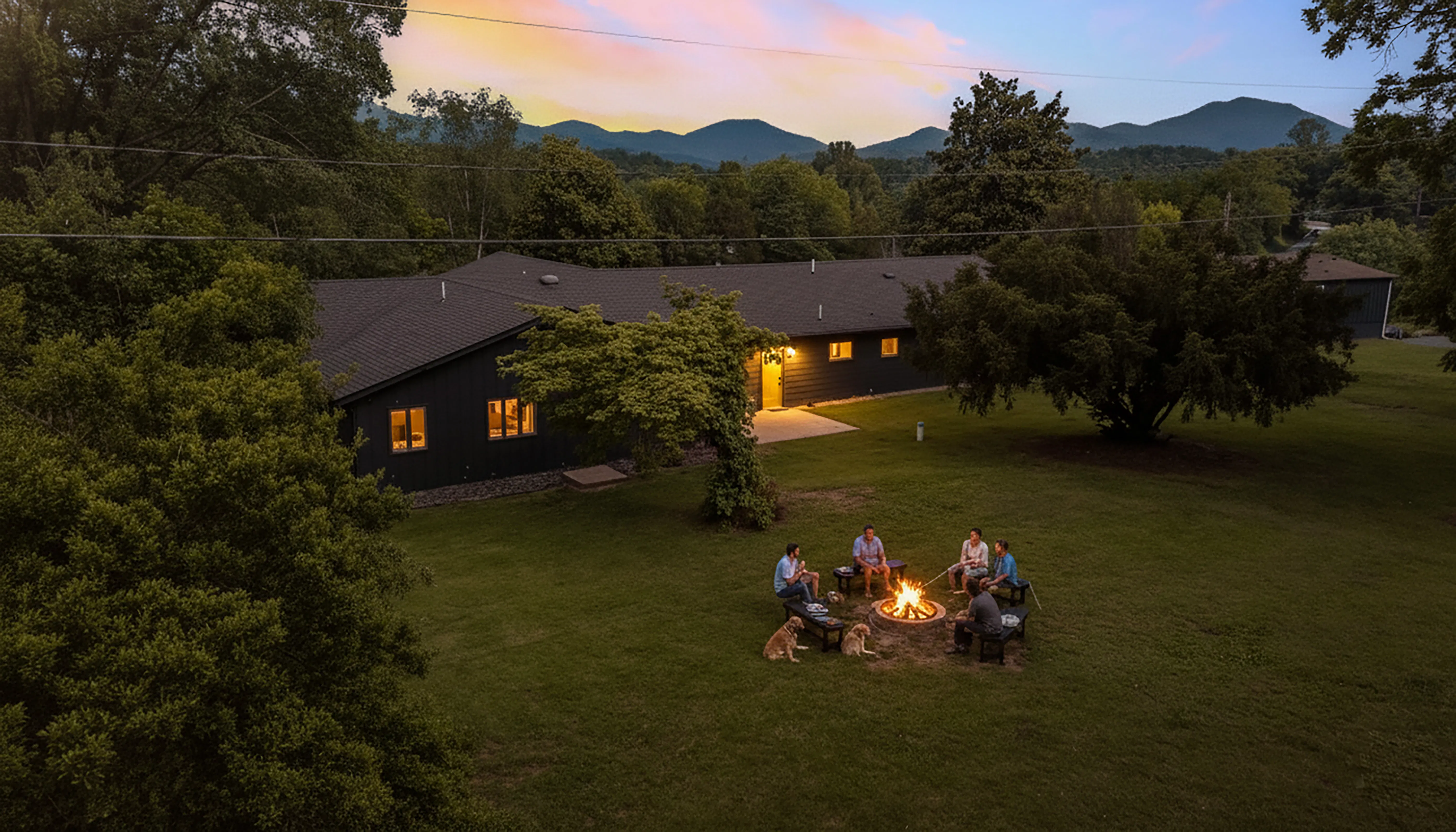 image This cozy retreat glows at dusk, its guests circling a crackling campfire beneath the fading light.