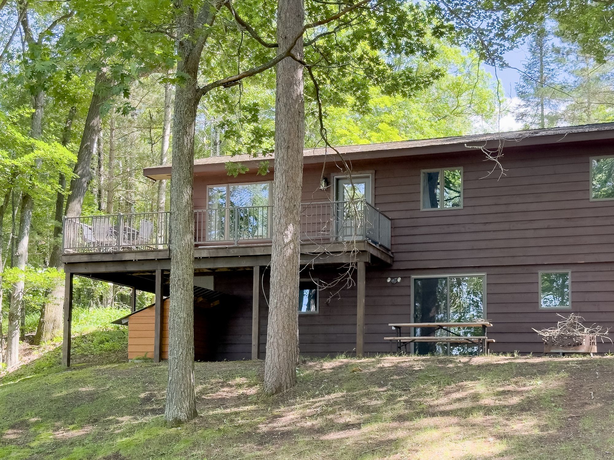 image Charming multi-level cabin with a spacious deck, surrounded by mature trees and just steps from the lake and trail system.