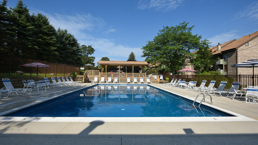 image Inviting outdoor pool surrounded by sunshine and fresh mountain air, ideal for relaxing summer days.