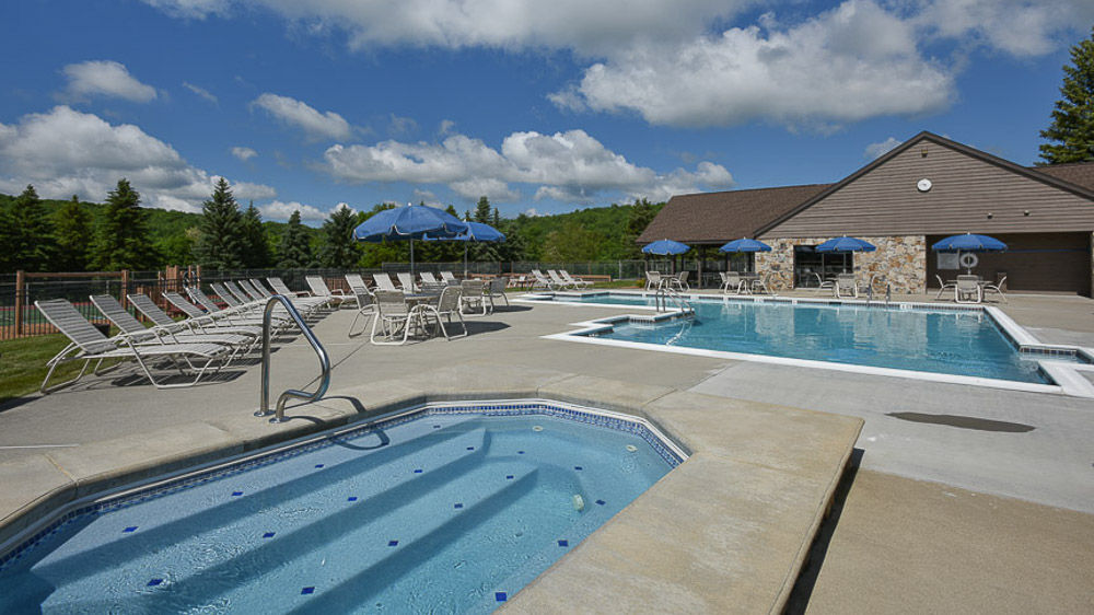 image Sparkling outdoor pool surrounded by mountain air and endless blue skies, where summer days unfold in pure relaxation.