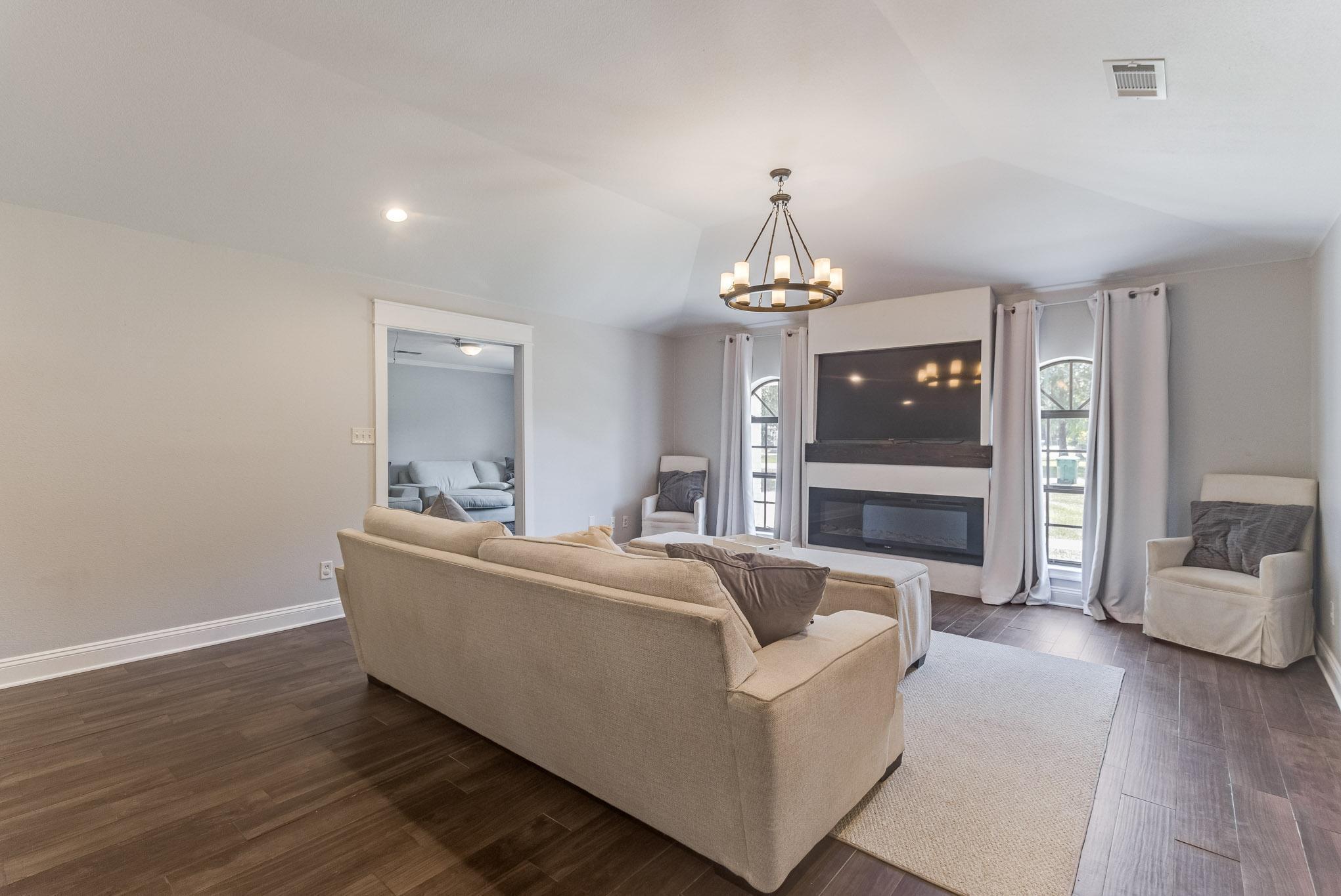 image Spacious living room with fireplace, plush seating, and warm natural light—perfect for cozy evenings.