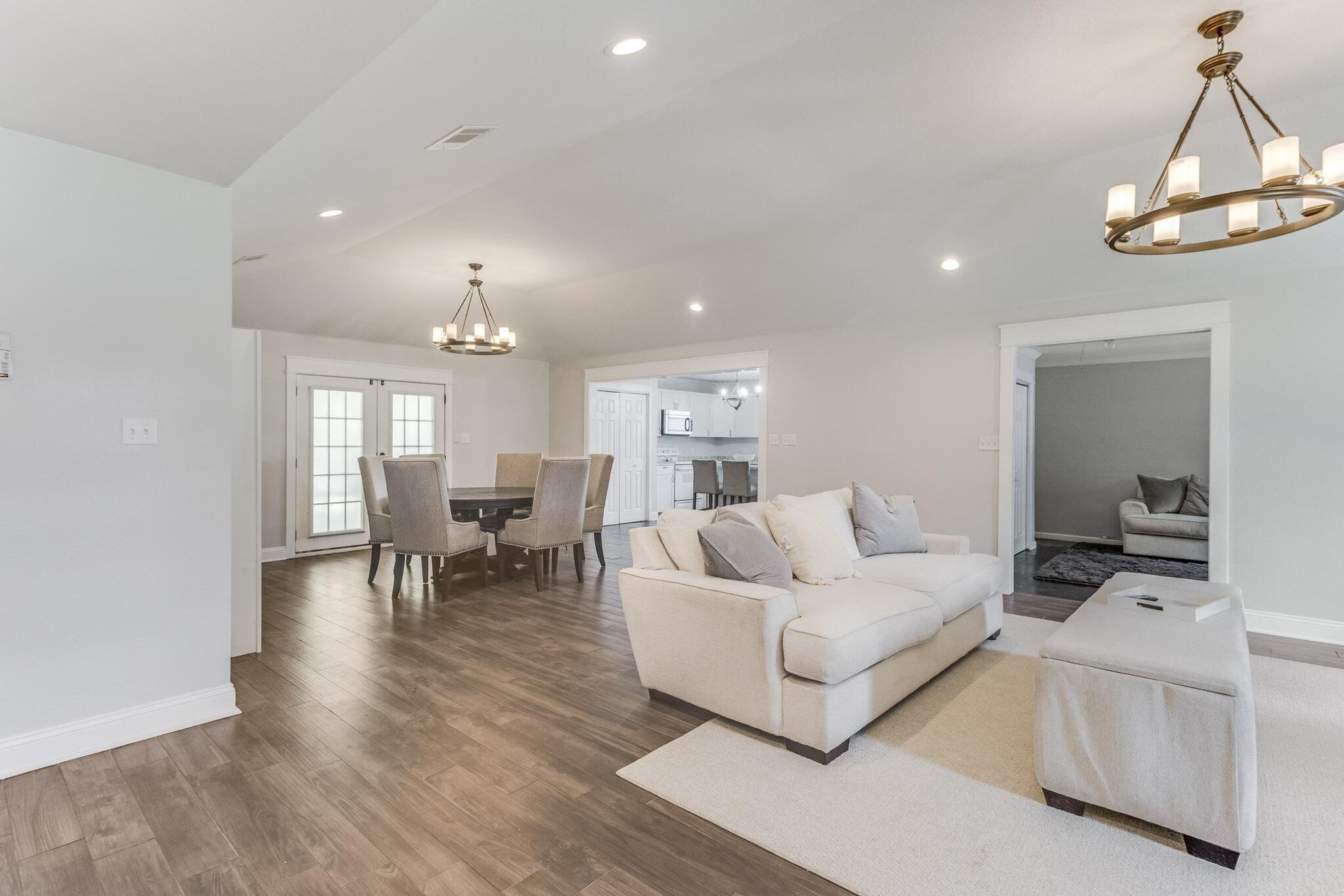 image Expansive open-concept layout with plush seating and adjacent dining area, great for group gatherings.