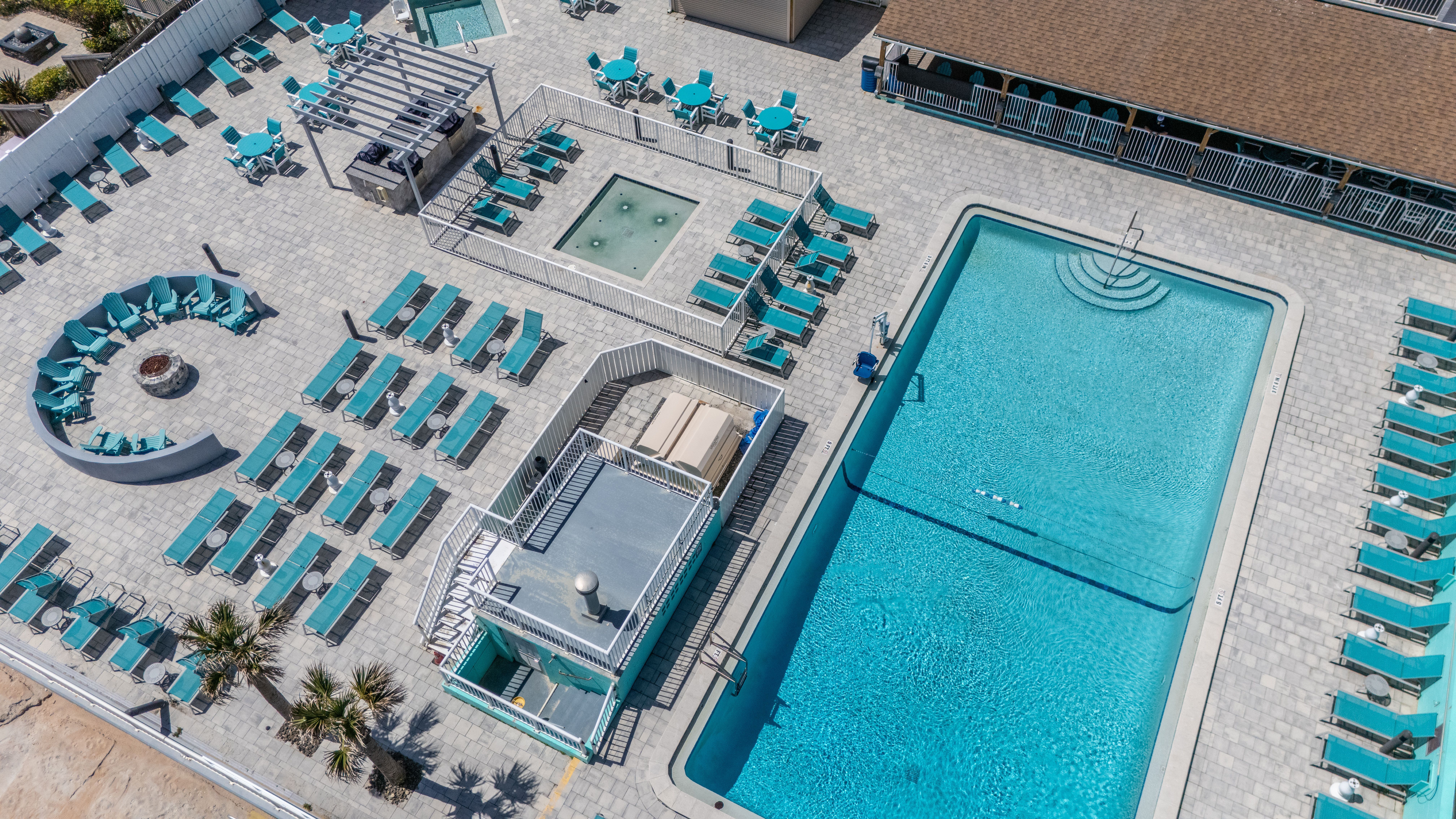 image Dive into the inviting pool area featuring comfortable seating and stunning ocean views, perfect for resort-style relaxation.