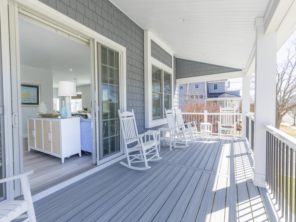 image Charming wraparound porch with rocking chairs and lounge seating—perfect for relaxing and watching the sunset.