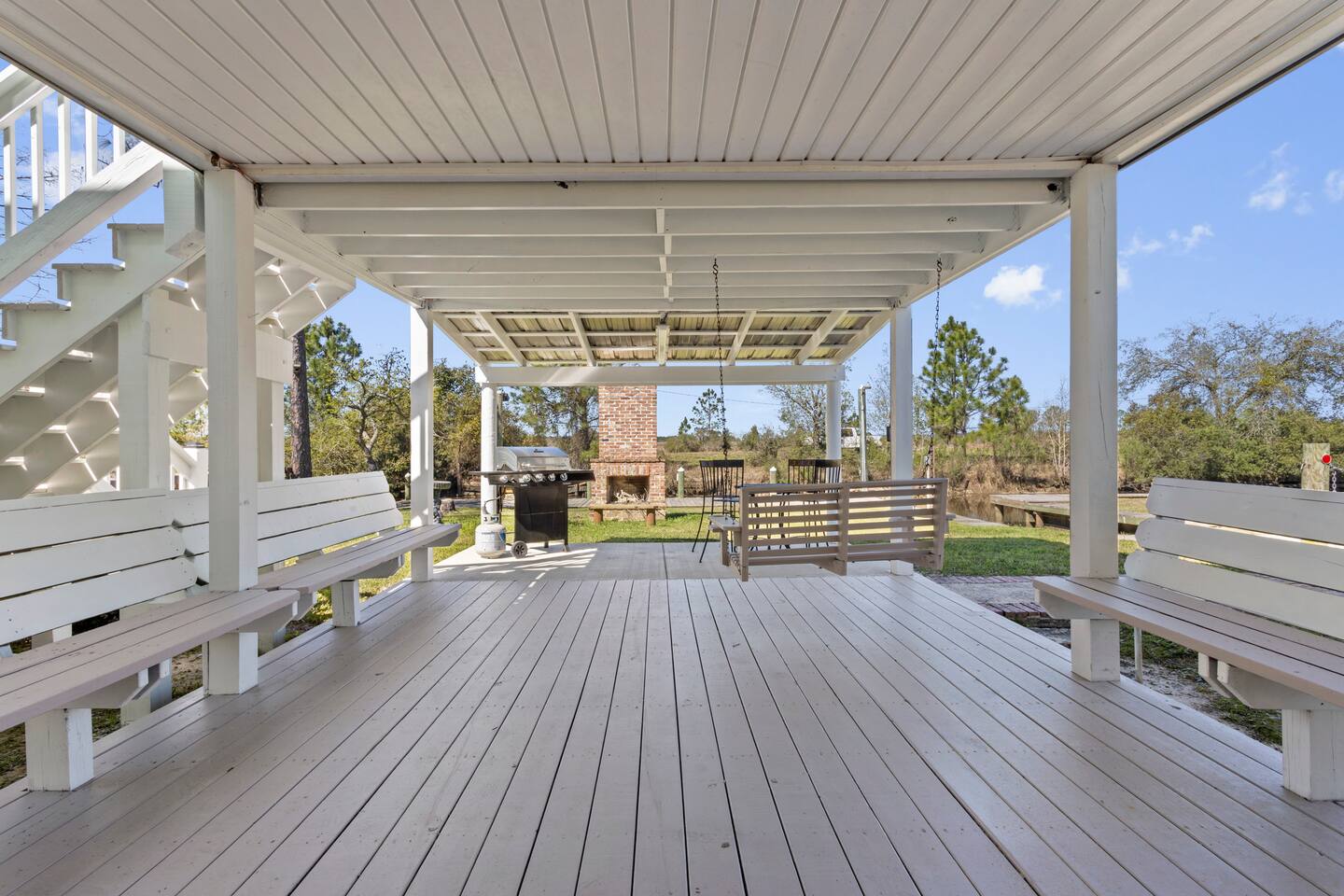 image A charming outdoor space with swings and benches, perfect for relaxation beneath the elevated patio.
