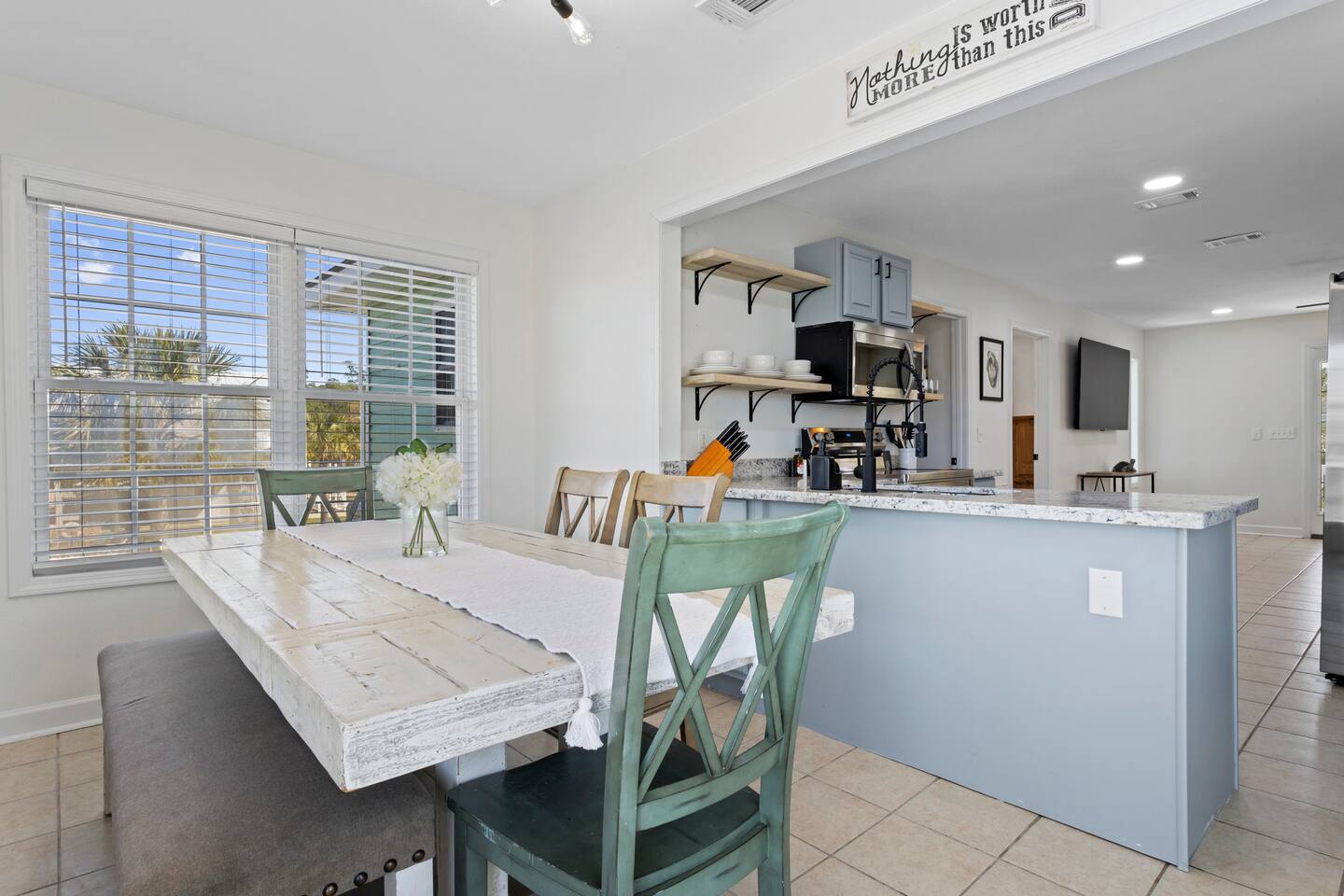 image A bright and airy dining area with a rustic table and modern kitchen setup, perfect for shared meals and gatherings.