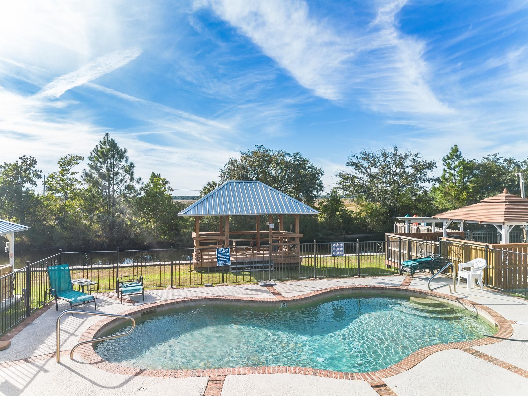 image Experience breathtaking views of the beautiful property from above, where lush greenery surrounds the sparkling pool and inviting outdoor spaces, a true slice of summer paradise.