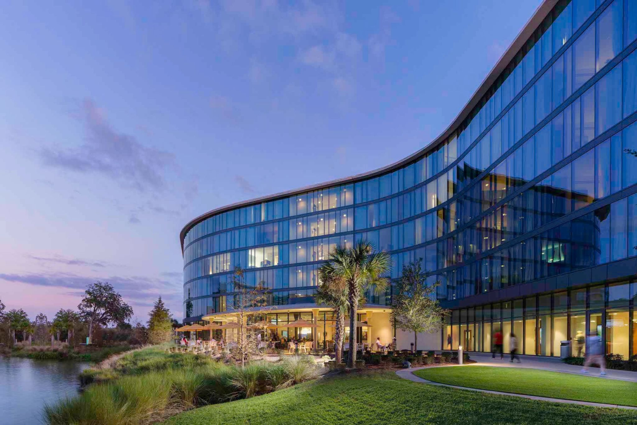 image The inviting exterior of Hotel ELEO features expansive windows that open to wellness spaces, blending luxury with a calming lakeside atmosphere.