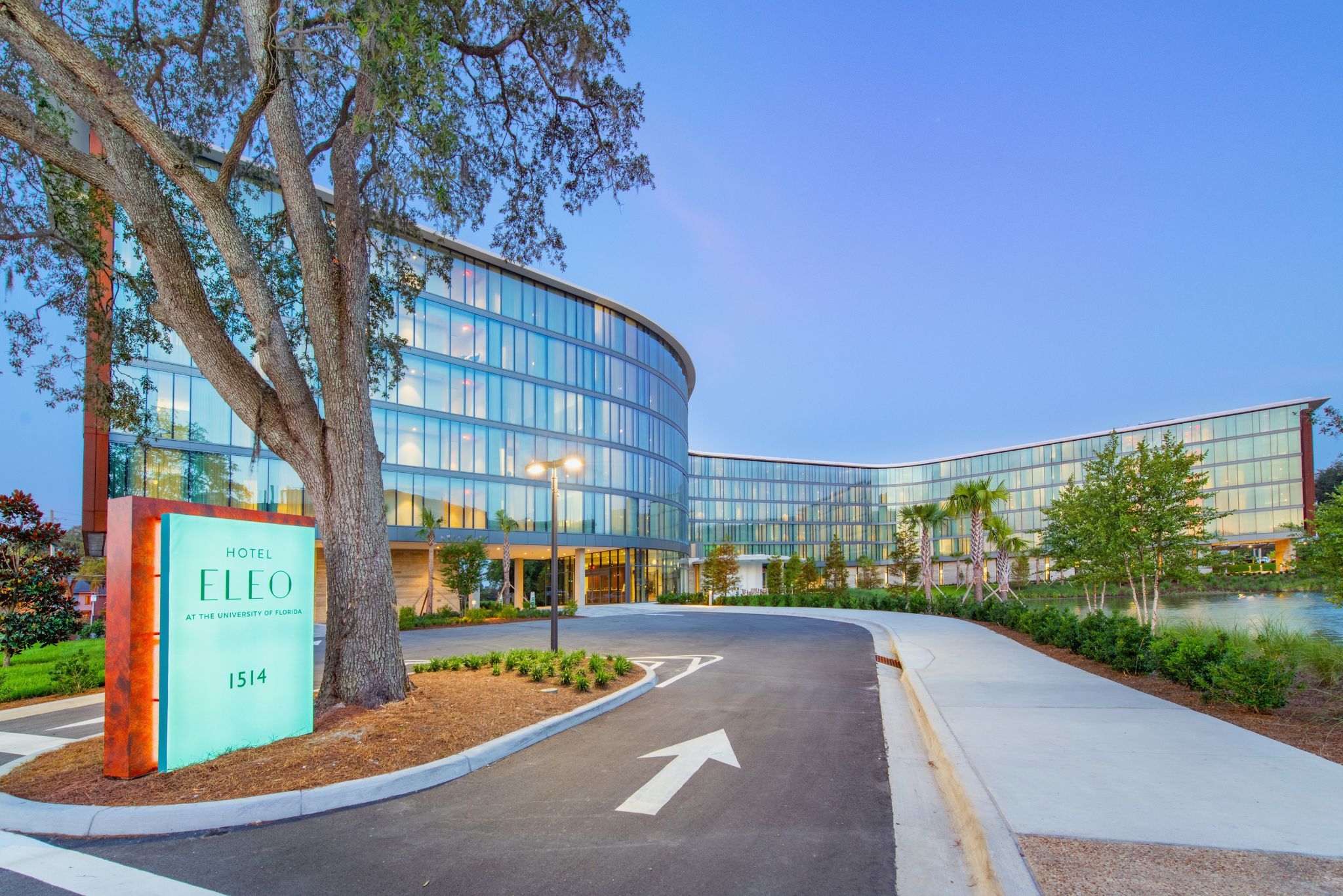 image The grand entryway of Hotel ELEO welcomes guests with modern design elements and lush landscaping, setting a sophisticated yet inviting tone.
