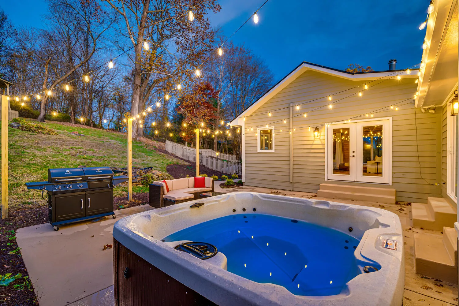 image Relax under the stars in the cozy hot tub, where soft lighting and serene countryside views set a tranquil evening mood.