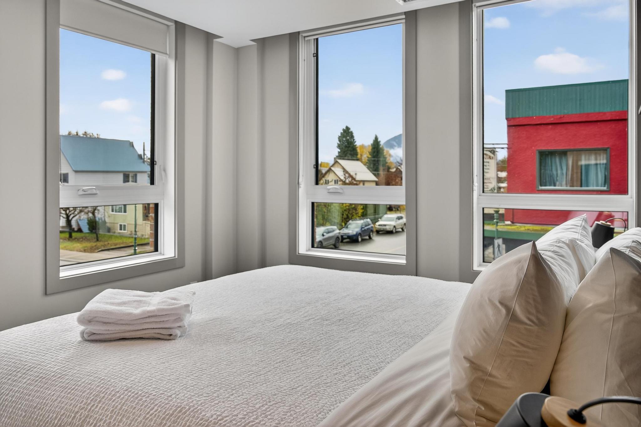 image Sunlight pours into the tranquil bedroom through expansive windows, highlighting a serene and welcoming environment that promises restful nights in this beautiful mountain retreat.