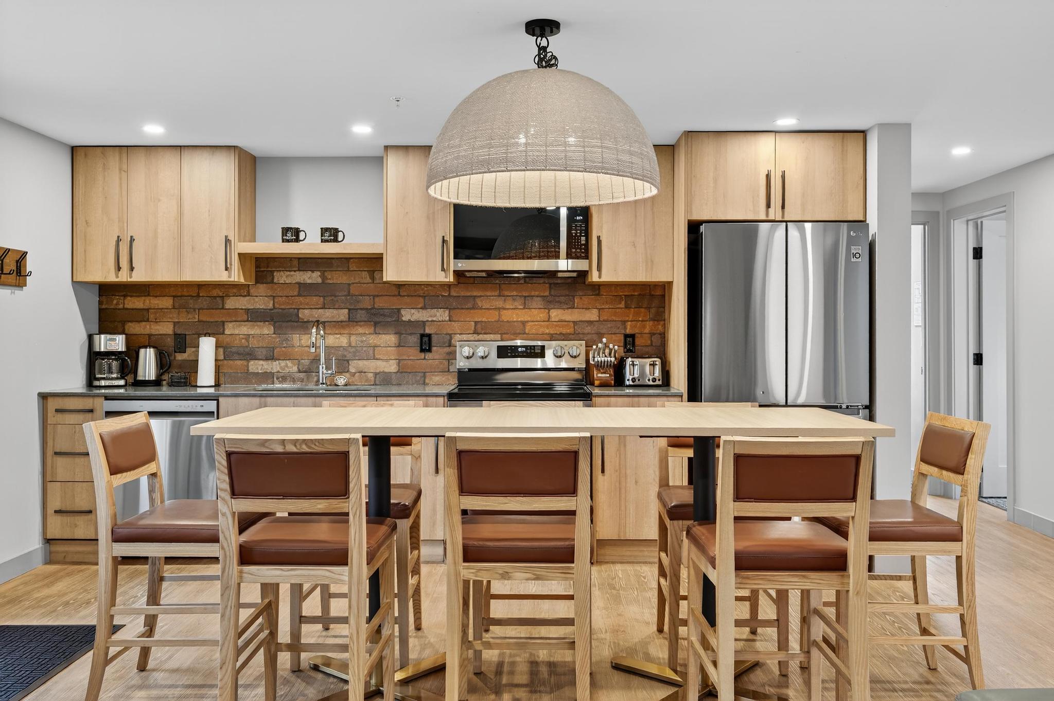 image The kitchen boasts a contemporary yet inviting atmosphere with its sleek cabinetry and distinctive brick backsplash, making it an ideal space for cooking after a day of adventure.