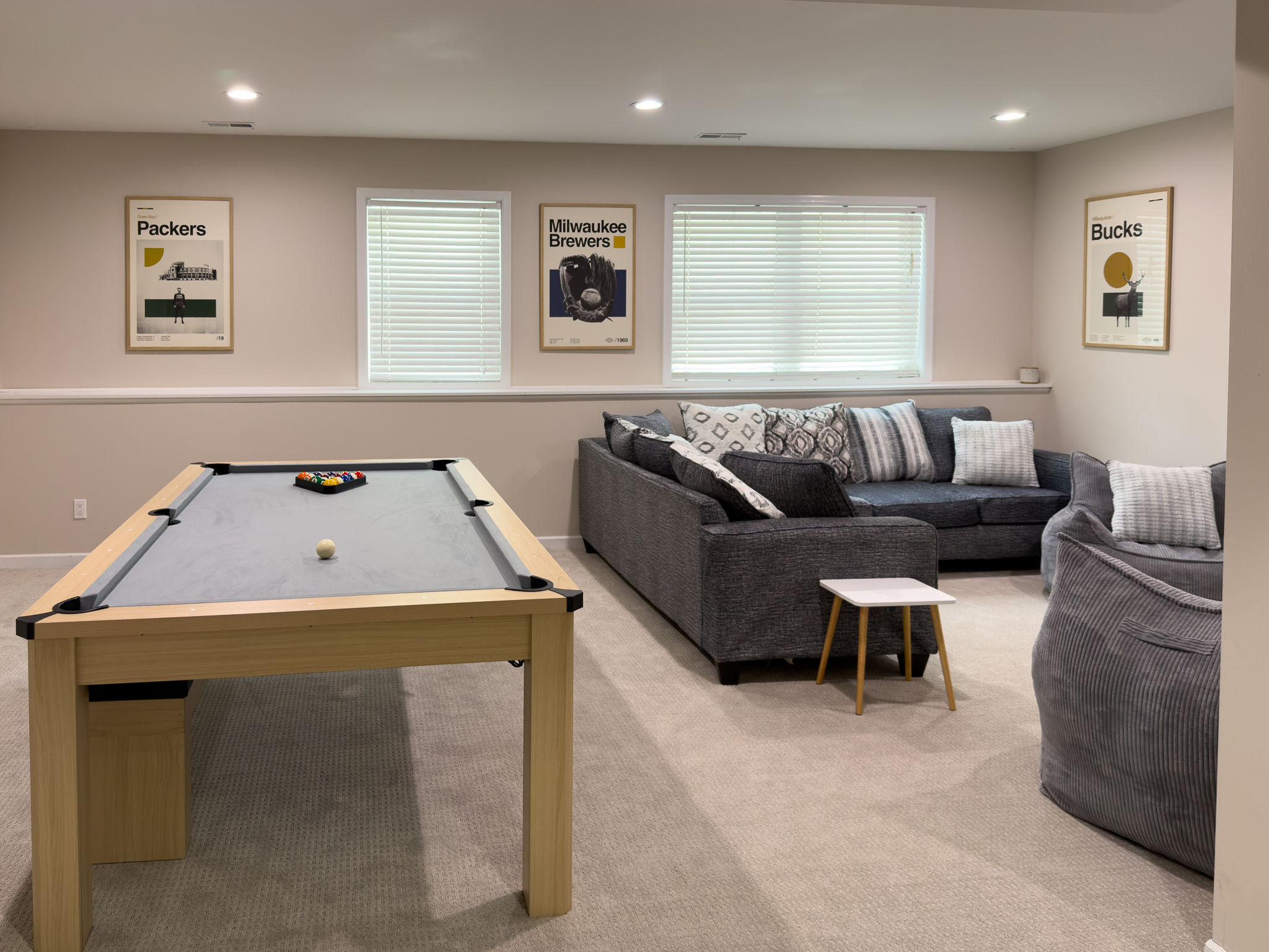 image This inviting game room features a stylish pool table and cozy seating, perfect for family fun and relaxation with framed sports memorabilia enhancing the ambiance.