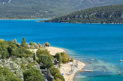 Nestled along the serene banks of the turquoise lake, Camping Verdon Les Grands Domaines invites guests to unwind amidst lush greenery and gentle waves, creating a perfect harmony with nature.