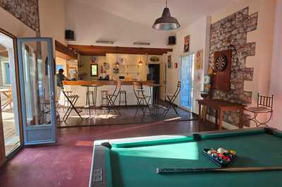 The vibrant bar area featuring stone walls, wooden accents, and natural light pouring in, creating a warm atmosphere.