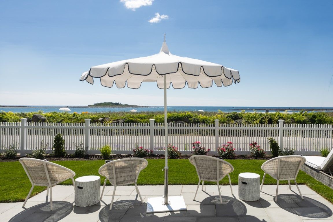 image A serene outdoor scene featuring cozy chairs under an umbrella, with breathtaking ocean views just a few steps away.