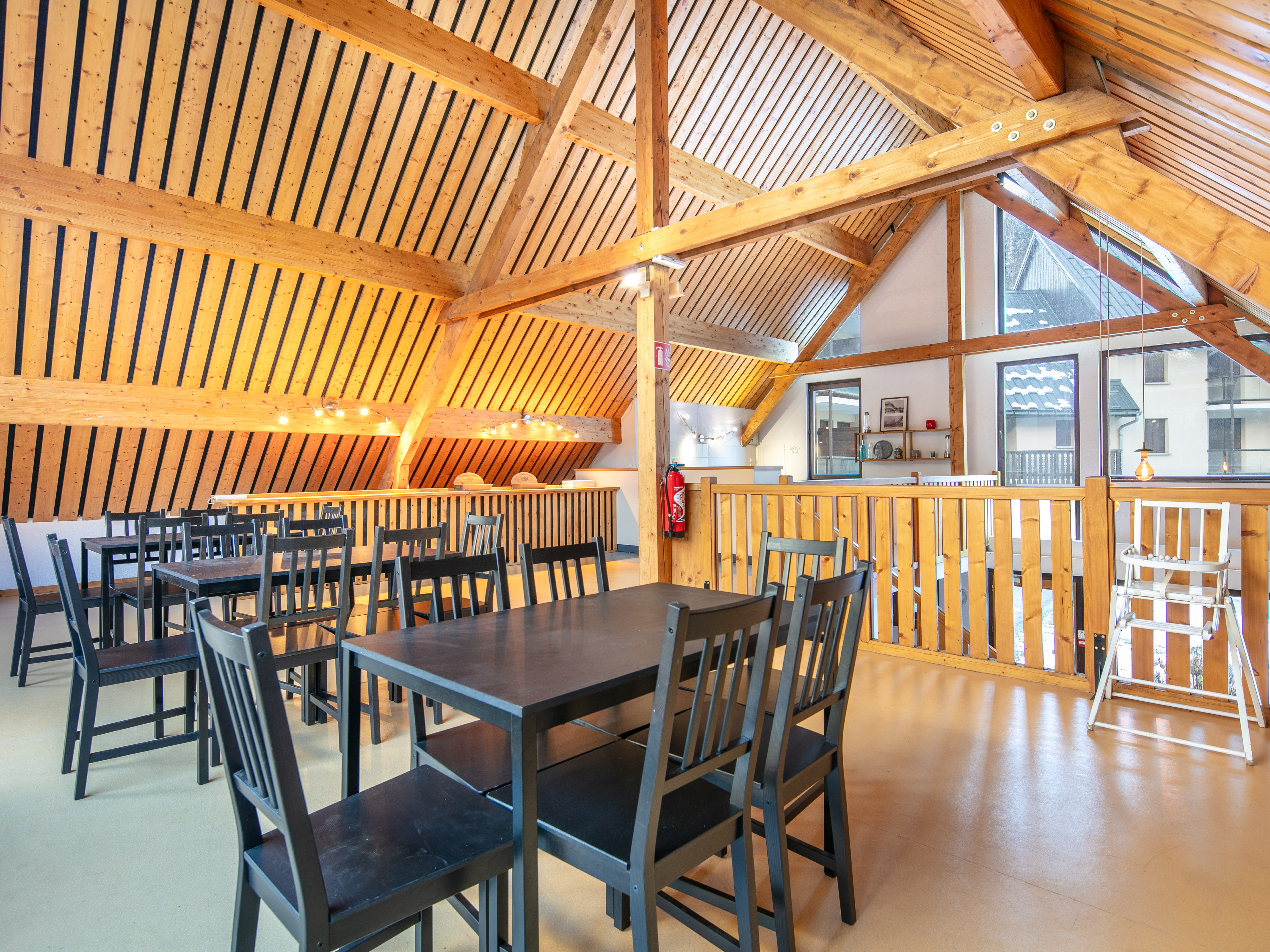 image Step into the cozy dining area of Résidence La Perrière, where the warm wooden beams and mountain views create an inviting atmosphere for shared meals.