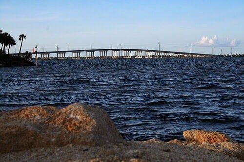 image Experience the beauty of the waterway, framed by shimmering waves and a stunning bridge.