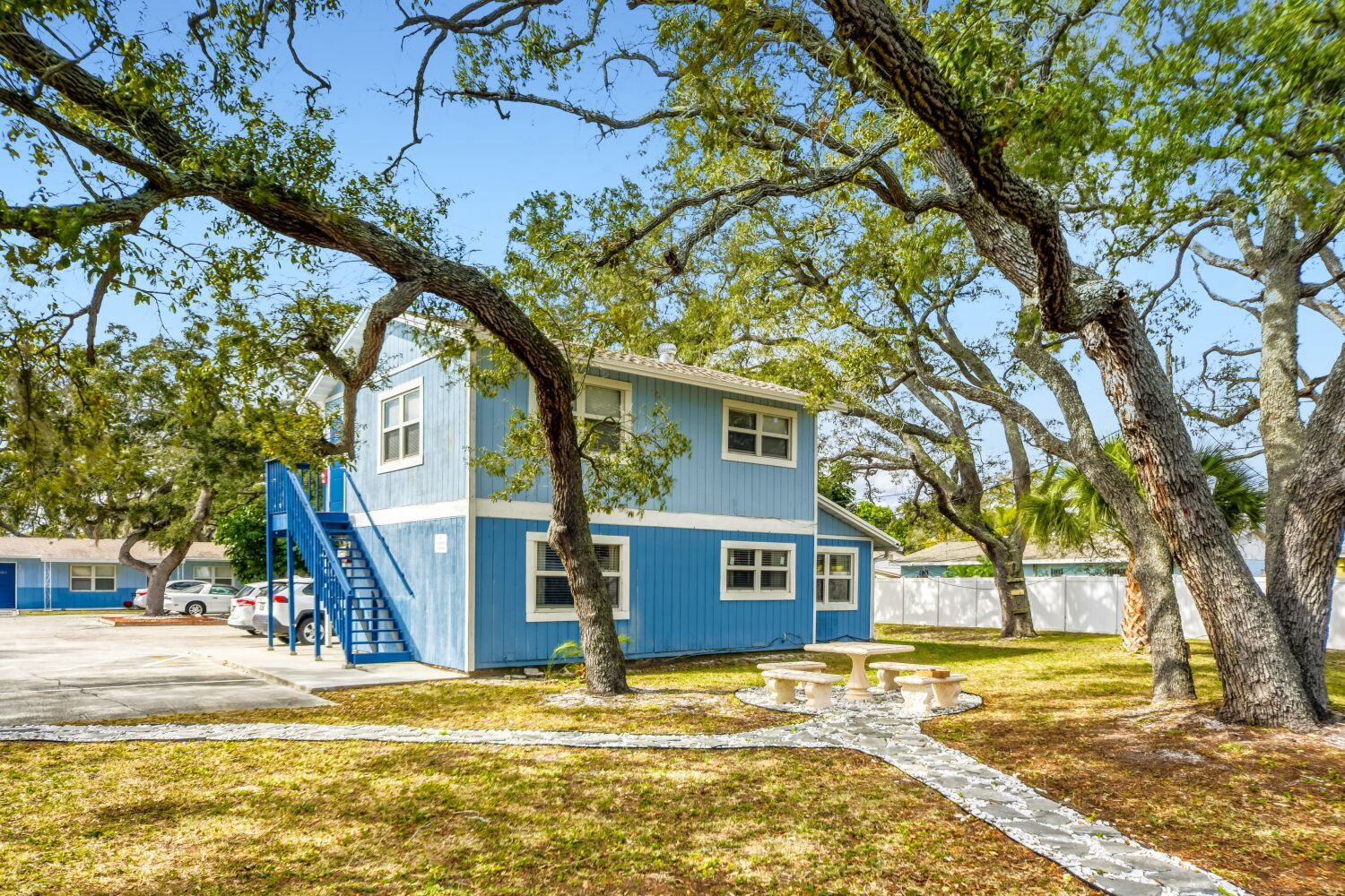 image Step outside to enjoy the vibrant colors of nature framed by lush trees and stylish blue buildings.