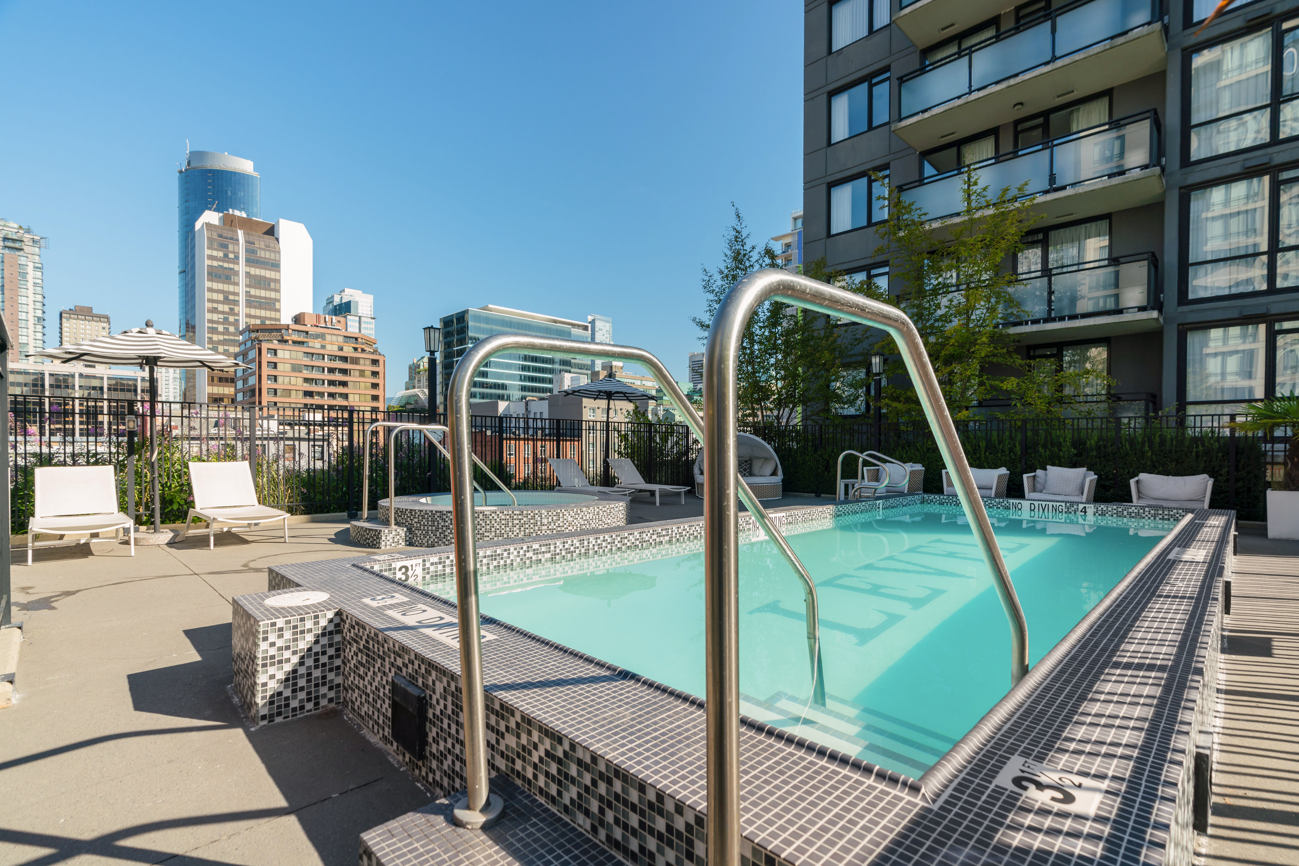image Rooftop outdoor pool with lounge seating and city views, offering a refreshing place to relax in the heart of Yaletown.